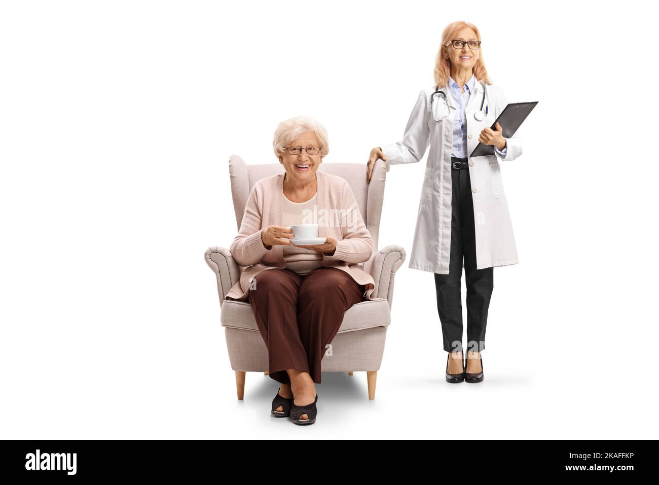 Femme médecin debout à côté d'une femme âgée dans un fauteuil avec une tasse de thé isolée sur fond blanc Banque D'Images