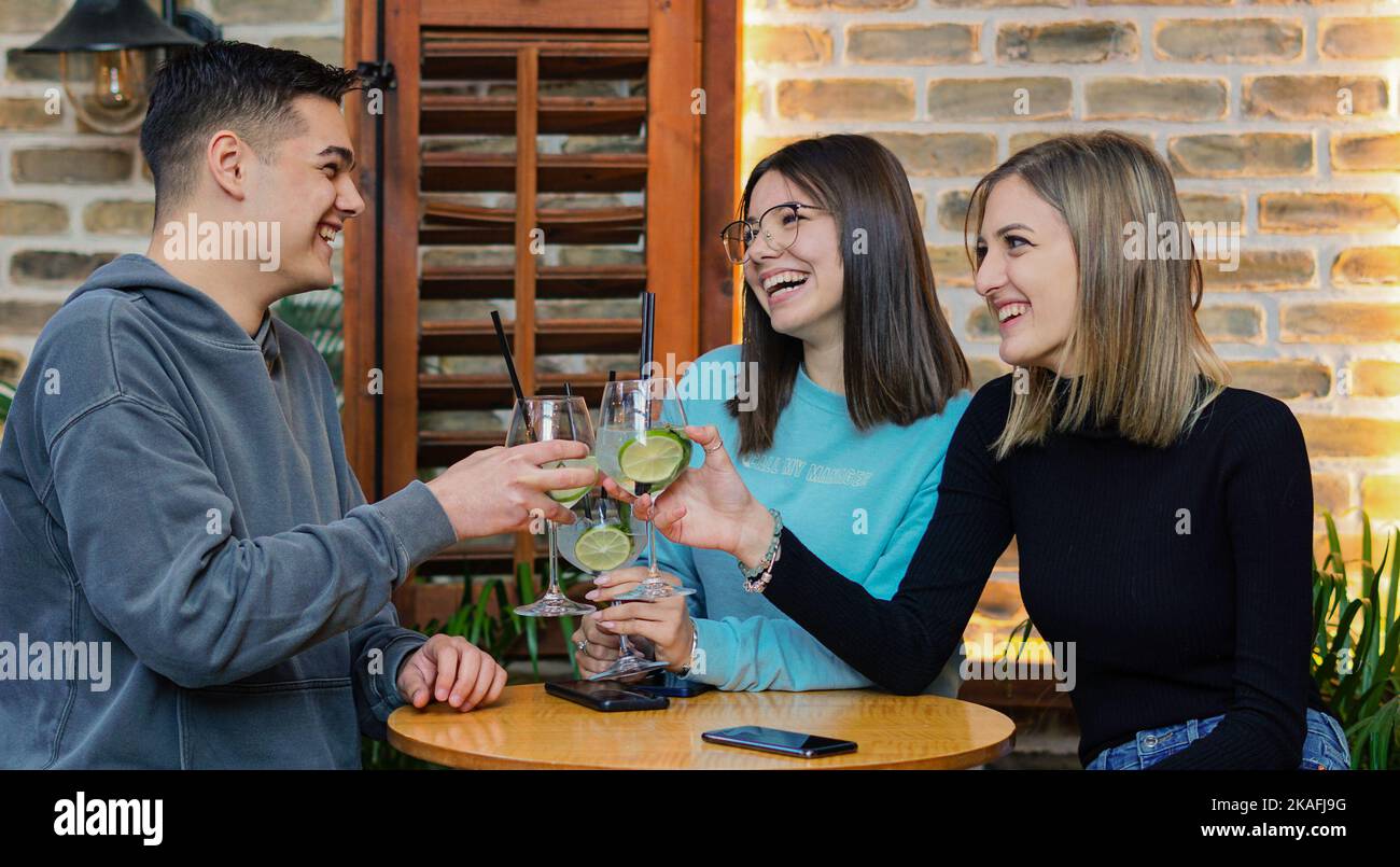 Les jeunes s'amusent dans un bar - des amis se sont amusés à boire des cocktails ensemble Banque D'Images