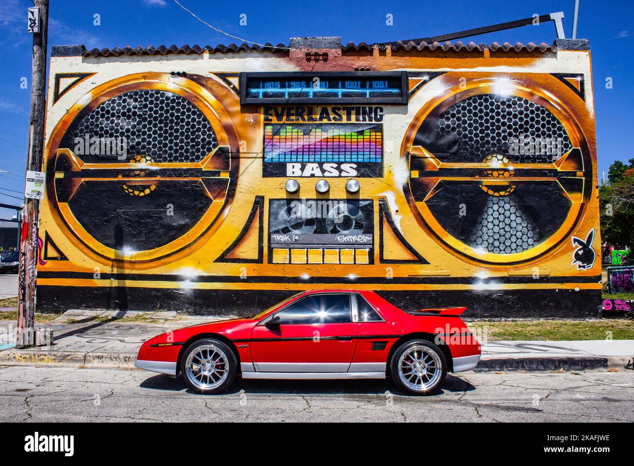 Un Fiero rouge 1984 de Pontiac devant une boîte de graffiti Banque D'Images