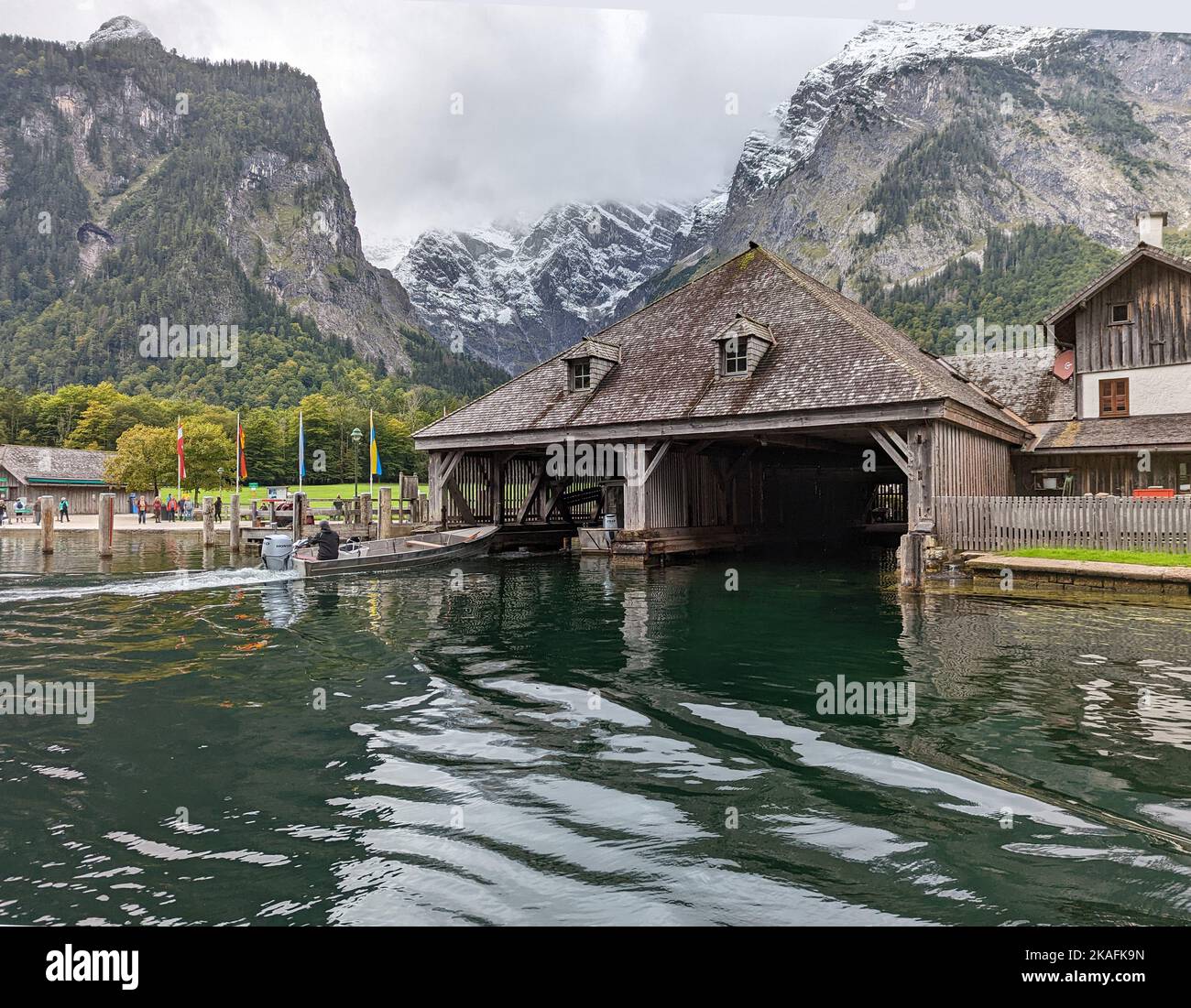 Un bateau à moteur de pêche qui se trouve dans le hangar à bateaux sur le lac Koenigsee, entouré de montagnes rocheuses Banque D'Images