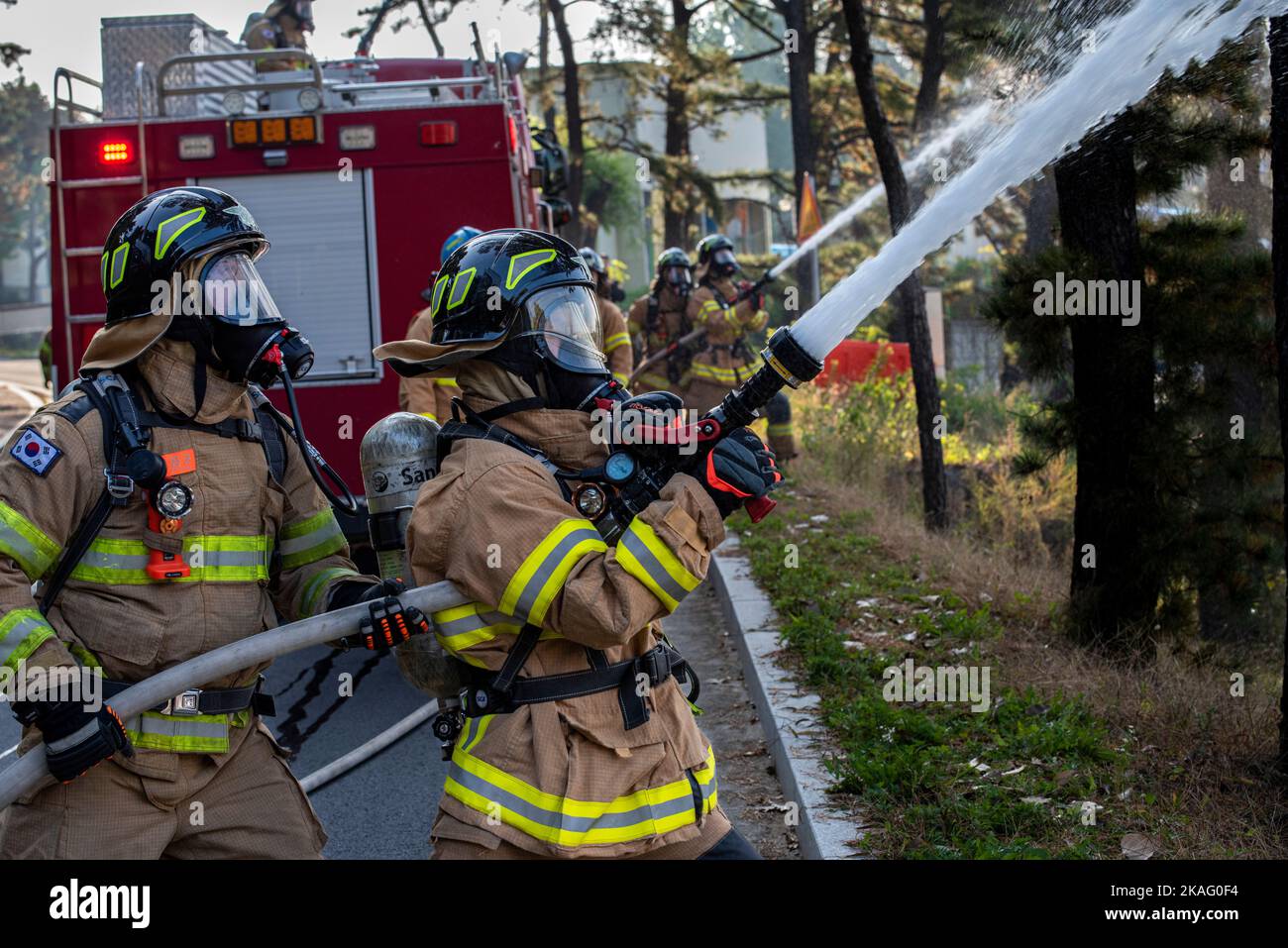 Les pompiers de la Force aérienne de la République de Corée pulvérisent de l'eau lors d'une simulation d'incendie au cours d'un exercice d'entraînement conjoint avec le Service des incendies de l'escadron du génie civil 51st à la base aérienne d'Osan, ROK, le 21 octobre 2022. La formation a été organisée pour accroître la préparation et renforcer la communication entre les pompiers des forces alliées. (É.-U. Photo de la Force aérienne par le sergent d'état-major. Dwane R. Young) Banque D'Images