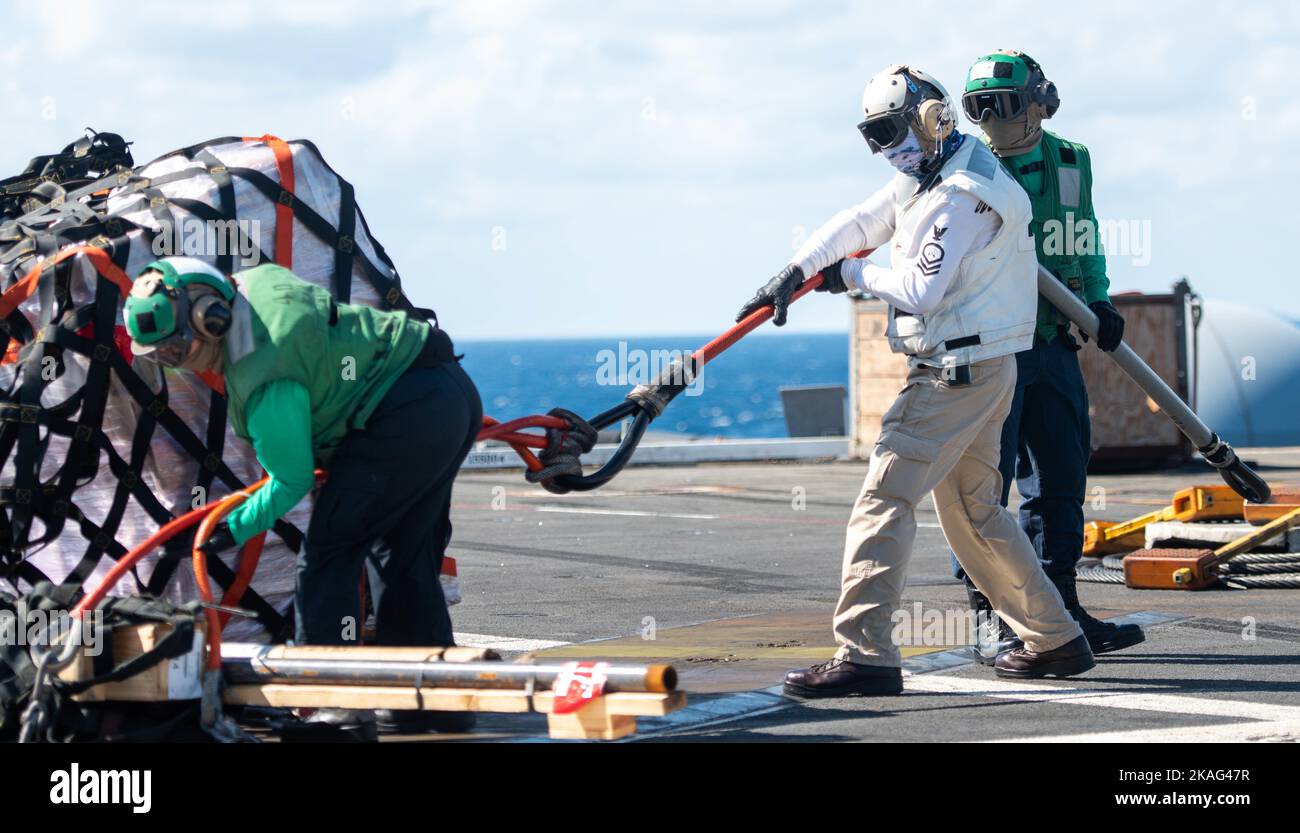 221030-N-UF592-1143 MER DES PHILIPPINES (OCT 30, 2022) les marins retirent un câble de transport sur le pont de vol du seul porte-avions déployé par l’avant de la marine américaine, l’USS Ronald Reagan (CVN 76), lors d’un réapprovisionnement en mer avec le navire de fret et de munitions du Commandement militaire de Sealift, USNS Carl Brashear (T-AKE 7), en mer des Philippines, le 30 octobre. Ronald Reagan, le navire amiral du Carrier Strike Group 5, fournit une force prête à combattre qui protège et défend les États-Unis, et soutient les alliances, les partenariats et les intérêts maritimes collectifs dans la région Indo-Pacifique. (É.-U. Bleu marine photo par masse Banque D'Images