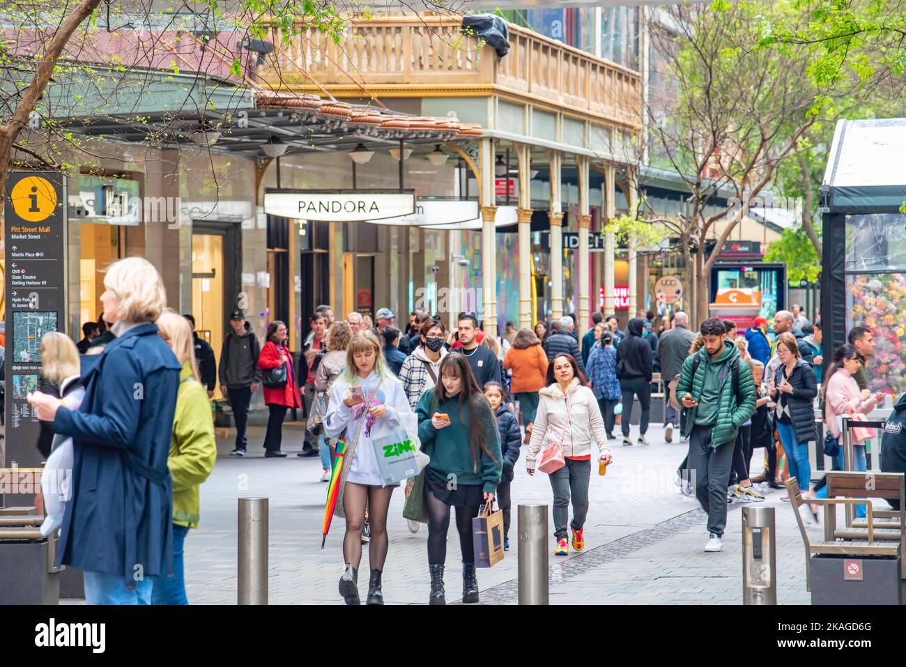 Les gens qui marchent et regardent ou lisent leurs téléphones mobiles lorsqu'ils se déplacent dans le centre commercial Pitt Street Mall, dans le quartier commercial de Sydney, en Australie Banque D'Images