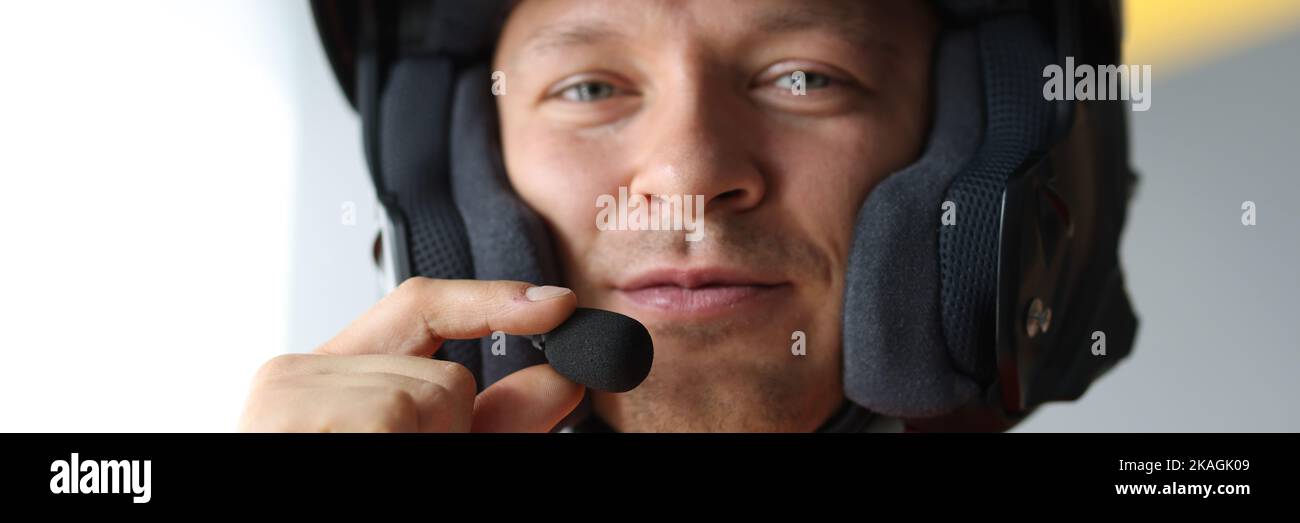 Homme portant un casque avec microphone pour une connexion mains libres, interphone pour motocyclistes Banque D'Images