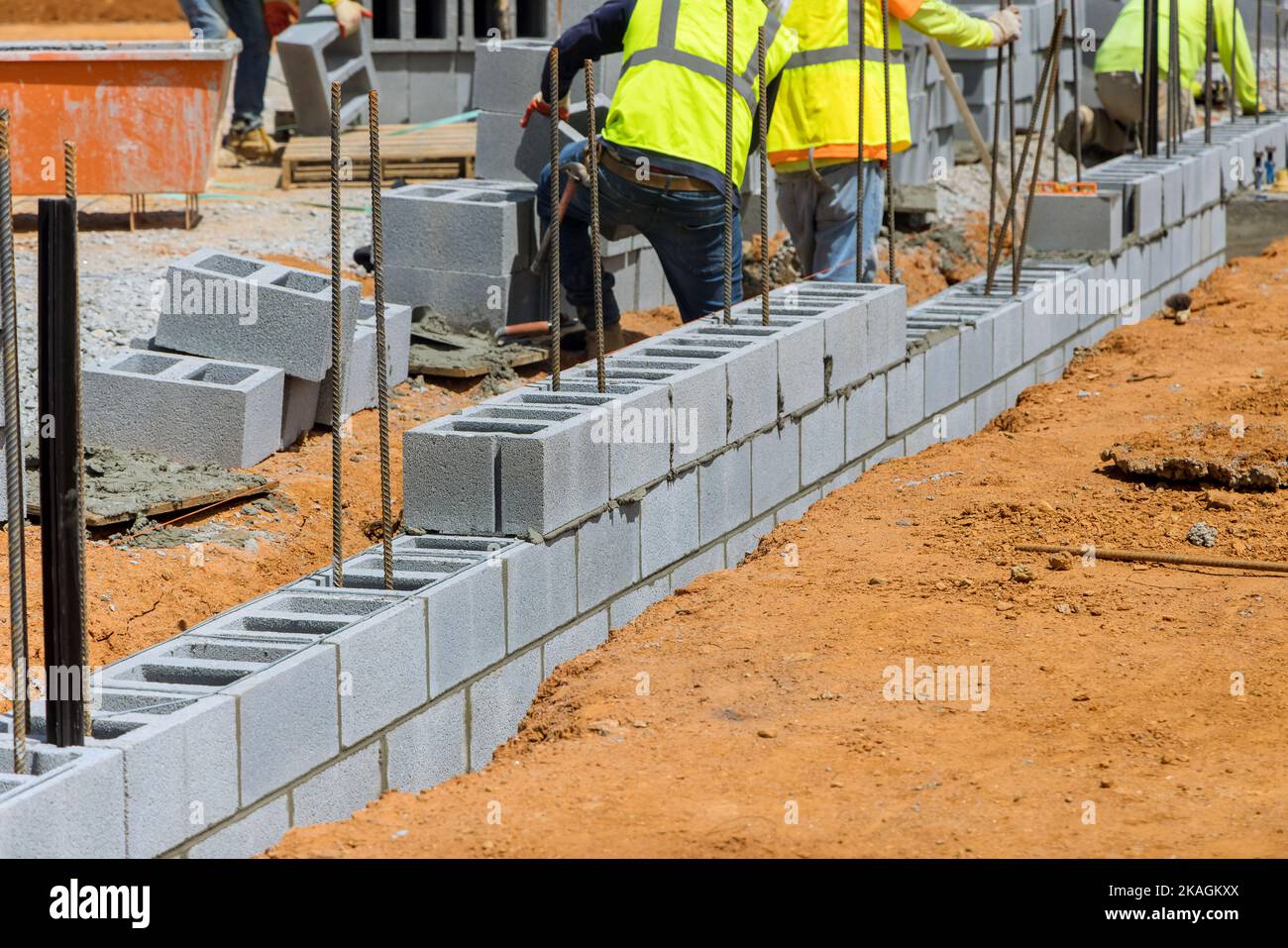 Un employé mason bricklayer entreprise posant le montage de blocs de béton de mur qui est partie de projet de construction Banque D'Images