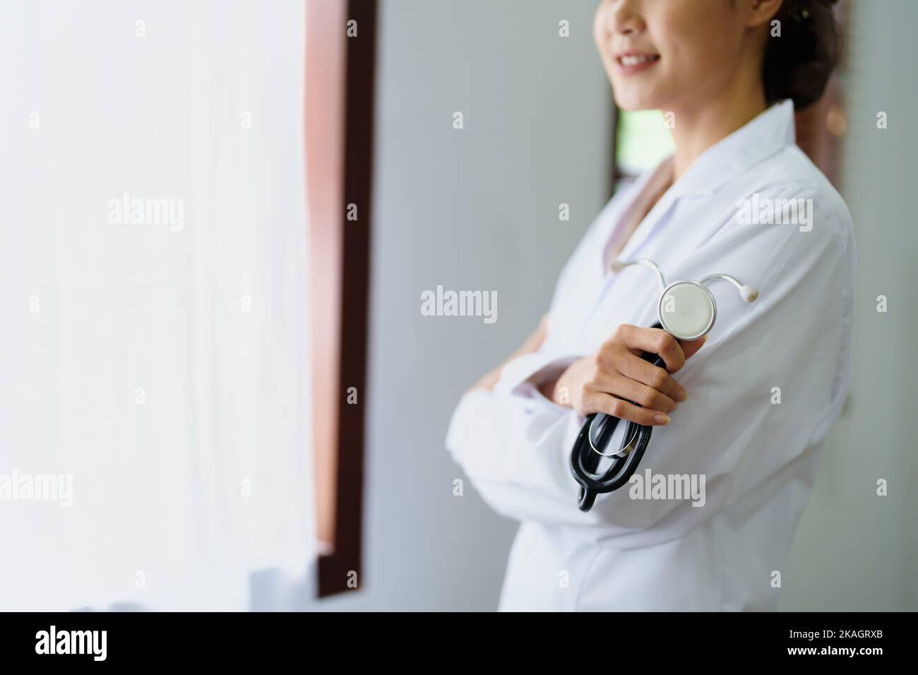 Portrait d'une femme asiatique médecin souriant avec joie tenant un stéthoscope après une pause de travail Banque D'Images