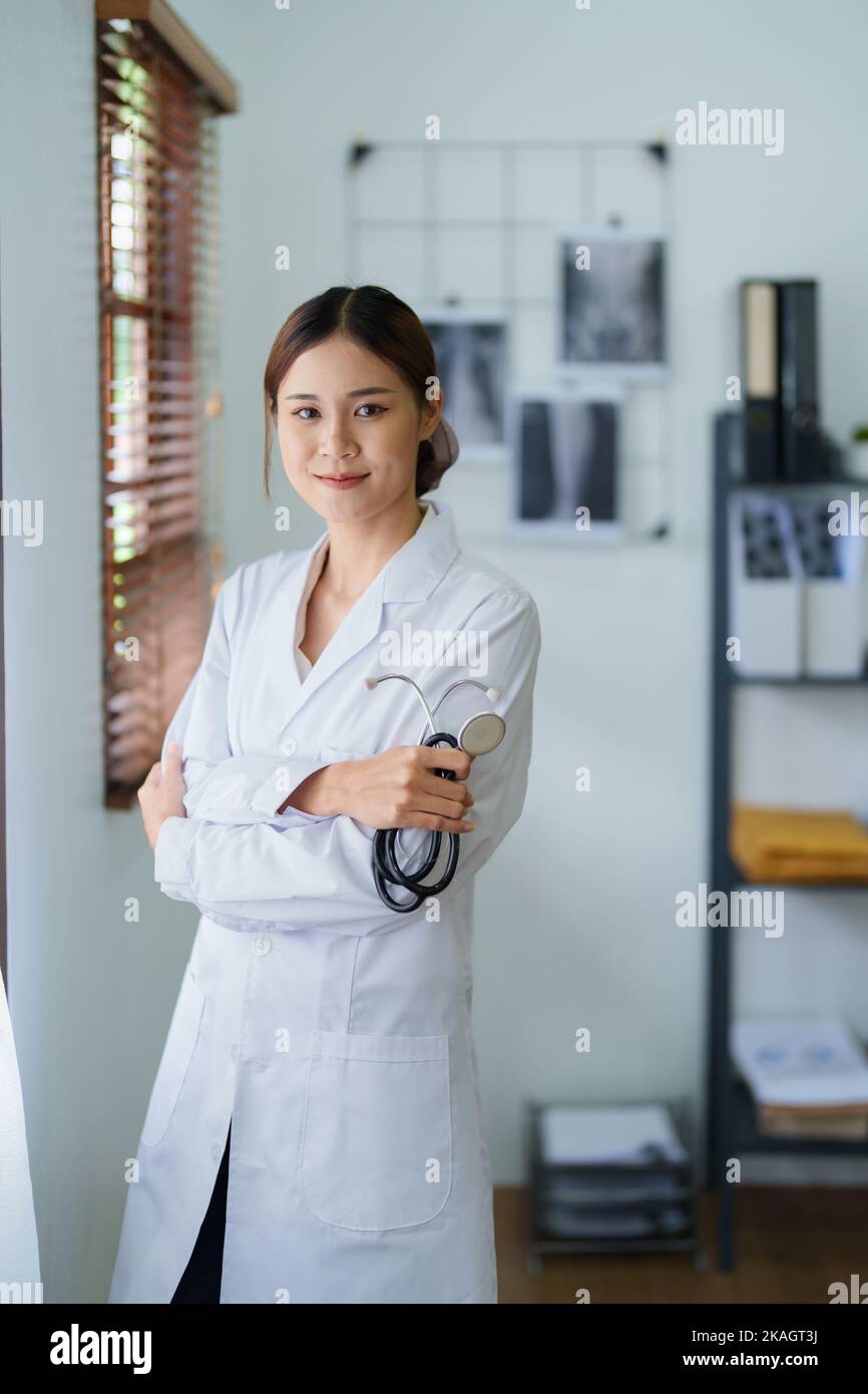 Portrait d'une femme asiatique médecin souriant avec joie tenant un stéthoscope après une pause de travail Banque D'Images