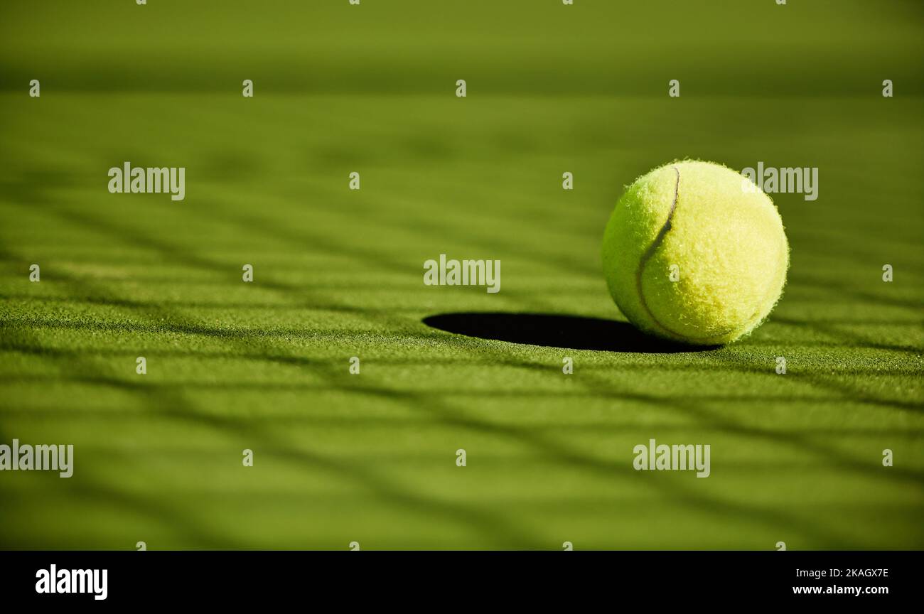 Tennis, sport et fitness avec ballon de tennis sur gazon, gros plan et texture vert, match de sport et compétition. Entraînement, actif et ballon de tennis Banque D'Images