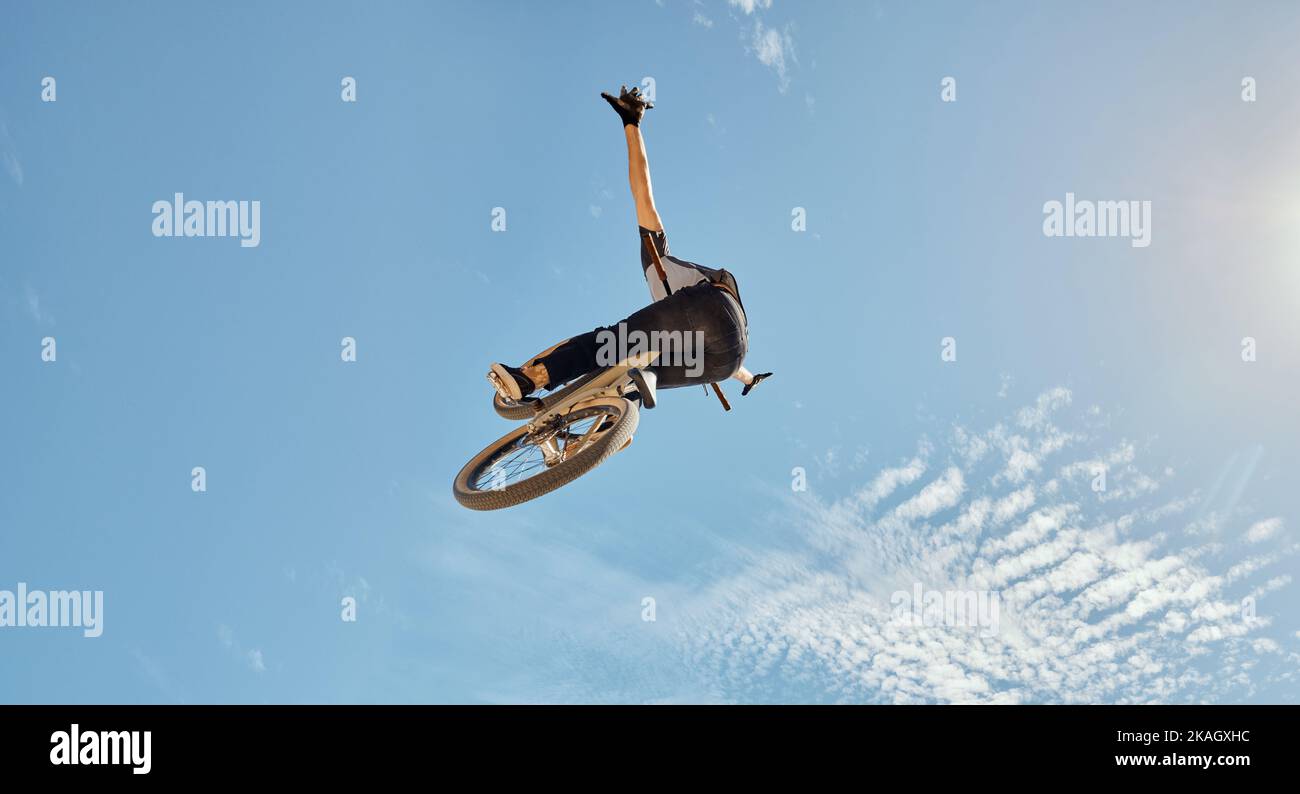 Randonnée à vélo, homme en vélo dans le saut à l'air sur le ciel bleu maquette pour des performances sportives d'action, d'entraînement de fitness ou de vélo d'extérieur. Professionnel Banque D'Images