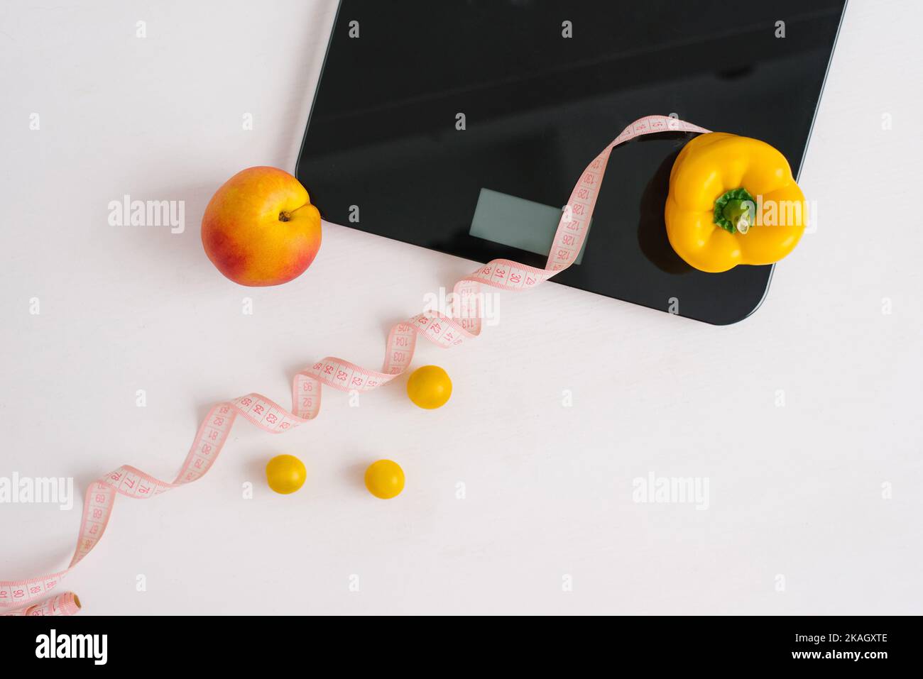 Pêche biologique et poivre et ruban de mesure pour peser les balances avec un régime de légumes végétaliens. Régime alimentaire et mode de vie sain. Design fin et fin. Banque D'Images