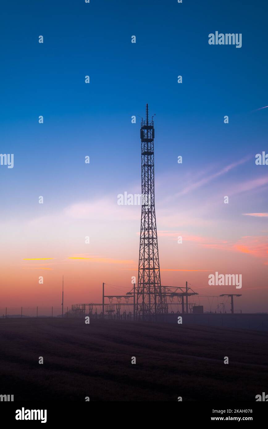 Relais Cell Tower en début de matinée sur fond de ciel orange Banque D'Images