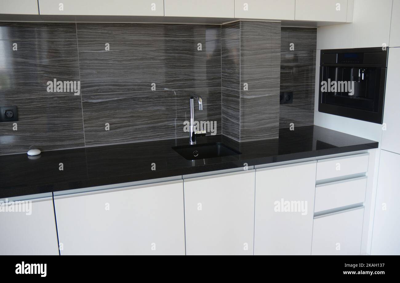 Gros plan sur une table de cuisine noire et blanche avec évier de cuisine et un café-purée intégré. Banque D'Images