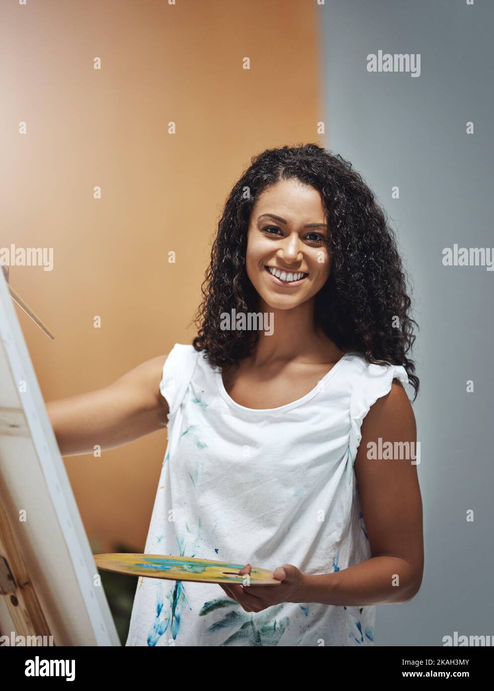 Regardez-moi faire de la magie créative. Portrait d'une jeune femme attrayante peint sur une toile à la maison. Banque D'Images