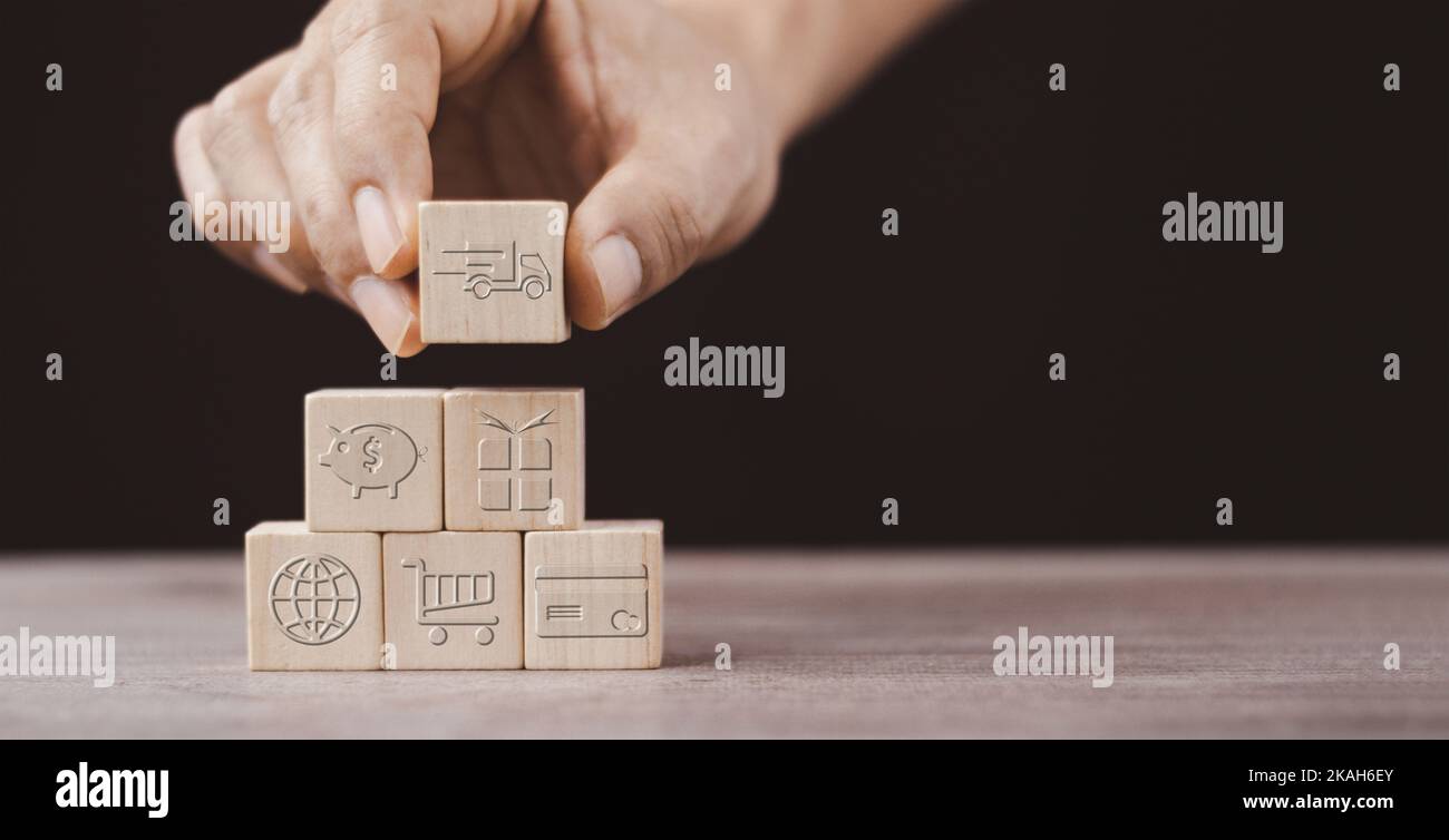 achat en ligne ou ecommerce concept avec icône d'affaires en ligne sur cube en bois sur fond noir Banque D'Images