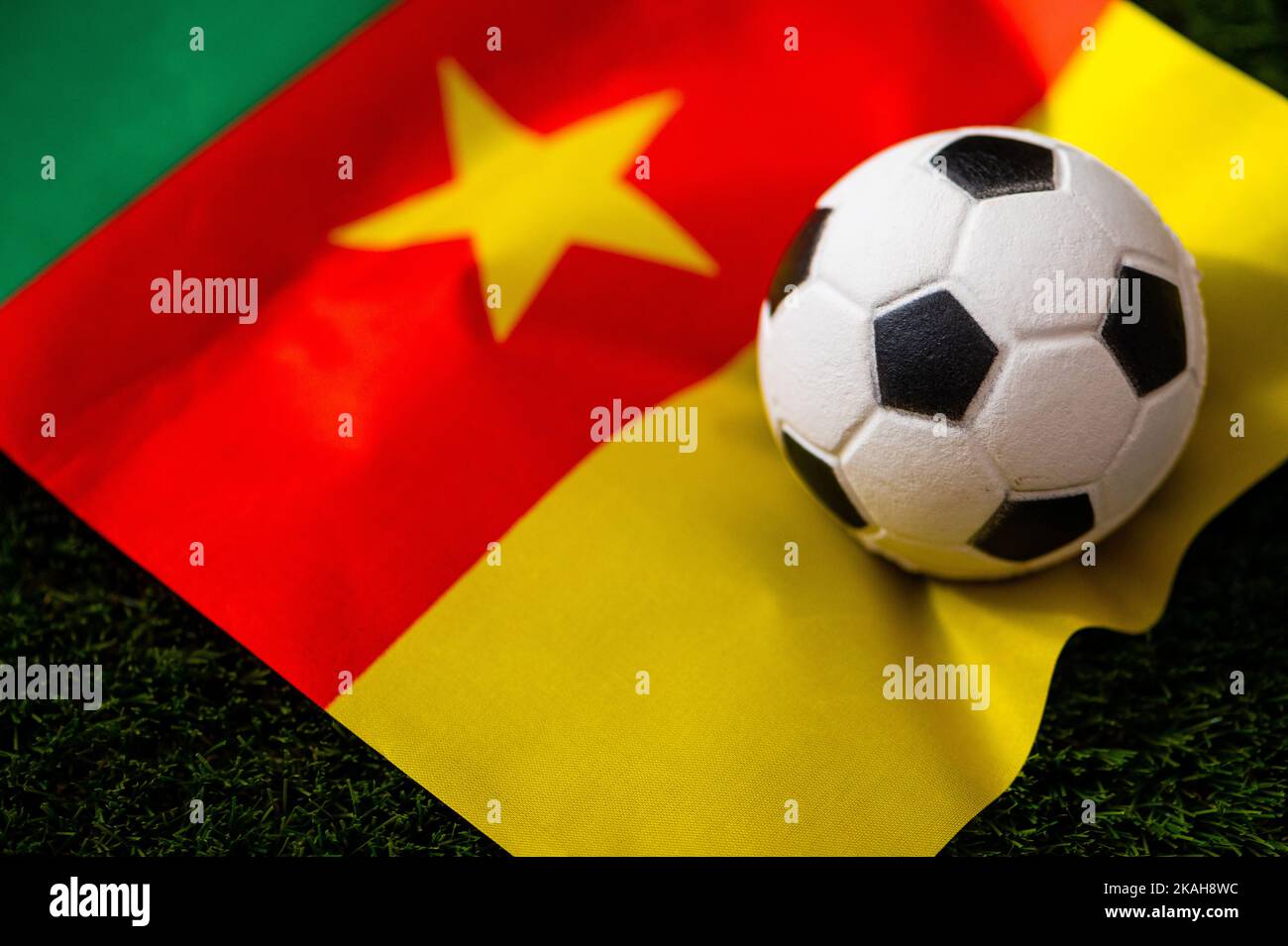 Équipe nationale de football du Cameroun. Drapeau national sur l'herbe verte et le ballon de football. Papier peint pour le championnat et le tournoi de football en 2022. Inter. Monde Banque D'Images