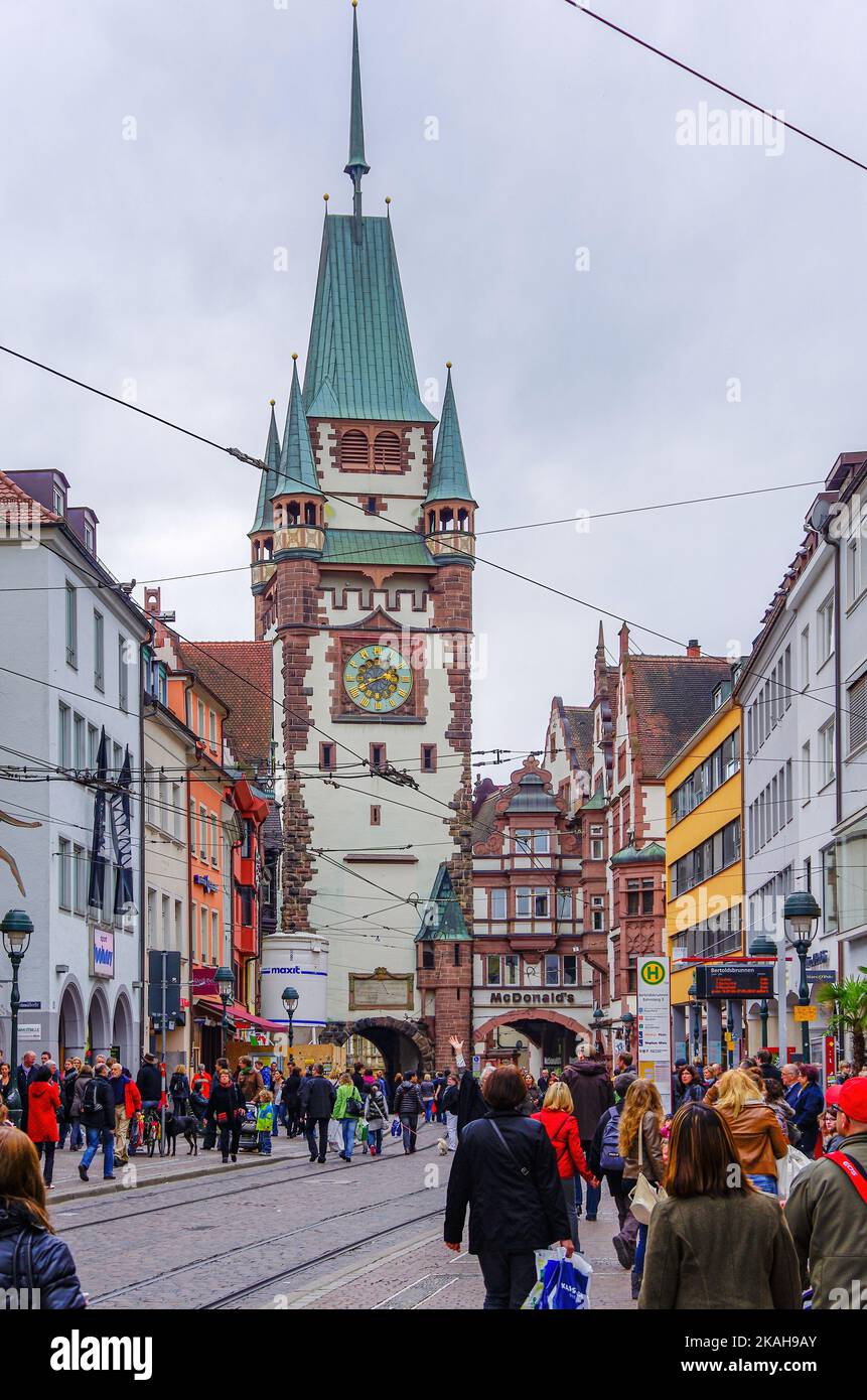 Scène de rue, Kaiser-Joseph-Strasse pleine de touristes, de citoyens et de piétons, face à la porte de Martin, vieille ville historique de Fribourg, Allemagne. Banque D'Images