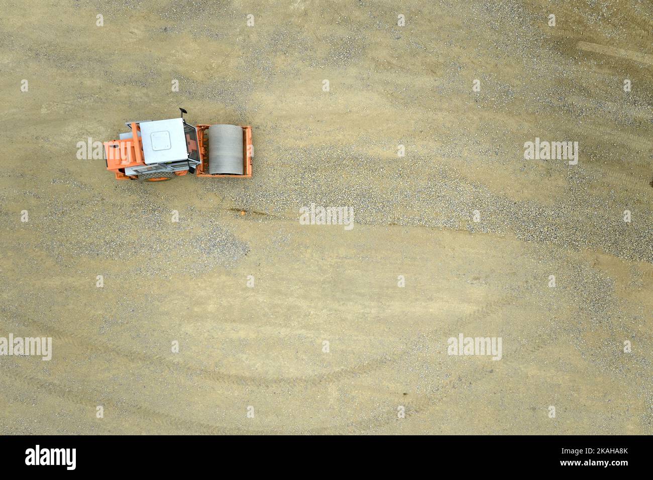 Vue verticale d'un rouleau de compacteur de sol isolé , machine de construction travaillant sur un chantier. Préparation de la base pour la fondation du parc Banque D'Images