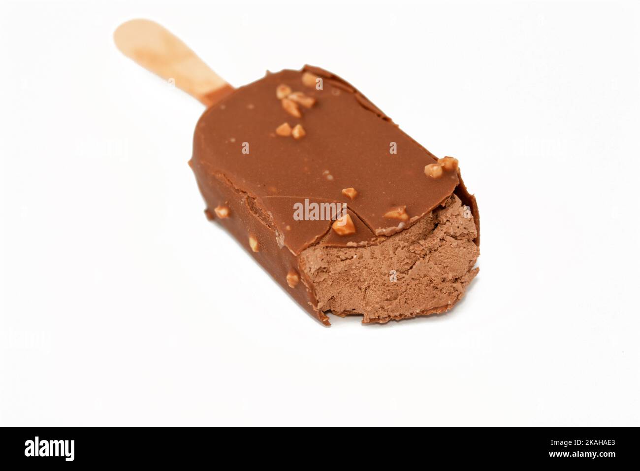 Bâton de glace au chocolat enrobé et recouvert d'une couche de chocolat noir avec des noix, de glace riche aromatisée dans le craquant au chocolat brun et Banque D'Images