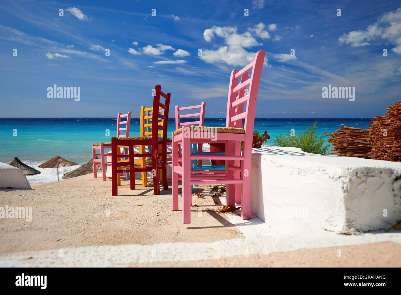 Chaises multicolores sur fond de mer vert-bleu et de ciel spectaculaire de la Riviera albanaise. Carte postale de la Méditerranée. Extérieur Banque D'Images