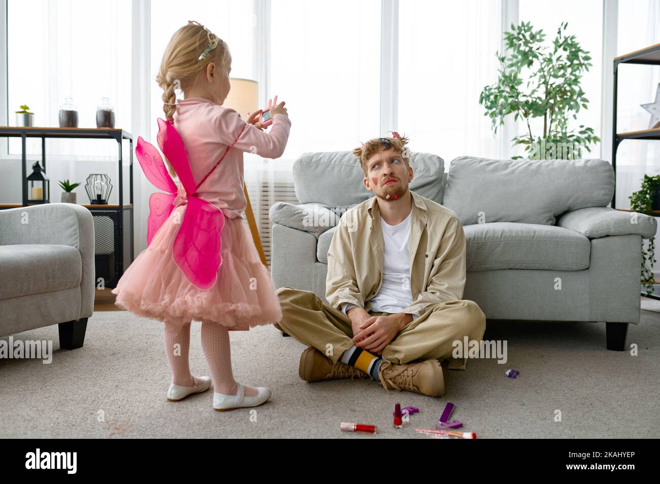 Fille faisant une photo de père avec maquillage drôle Banque D'Images