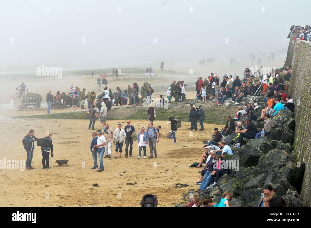 Les gens quittent la plage d'Arramanches, avec le temps brumeux et les conditions météorologiques qui s'aggravent très rapidement, le 72th anniversaire du jour J à Arromanches. Le lundi 6 juin 2016, à Arromanches, Calvados, Normandie, France. Photo par Artur Widak *** Veuillez utiliser le crédit du champ de crédit *** Banque D'Images