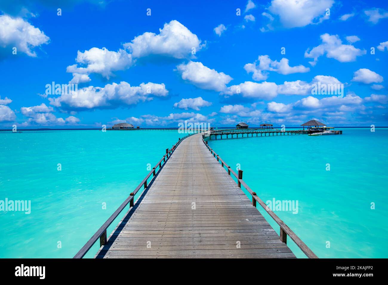 Lagon océanique calme et méditational avec ciel bleu ensoleillé. Vue naturelle idyllique avec longue jetée en bois dans l'île paradisiaque, destination de voyage de luxe Banque D'Images