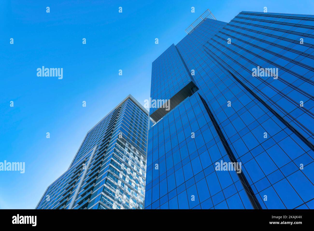 Des appartements modernes se dressent sur fond bleu ciel par temps ensoleillé. Vue sur la façade des bâtiments résidentiels avec l'architecture de logement contemporain Banque D'Images