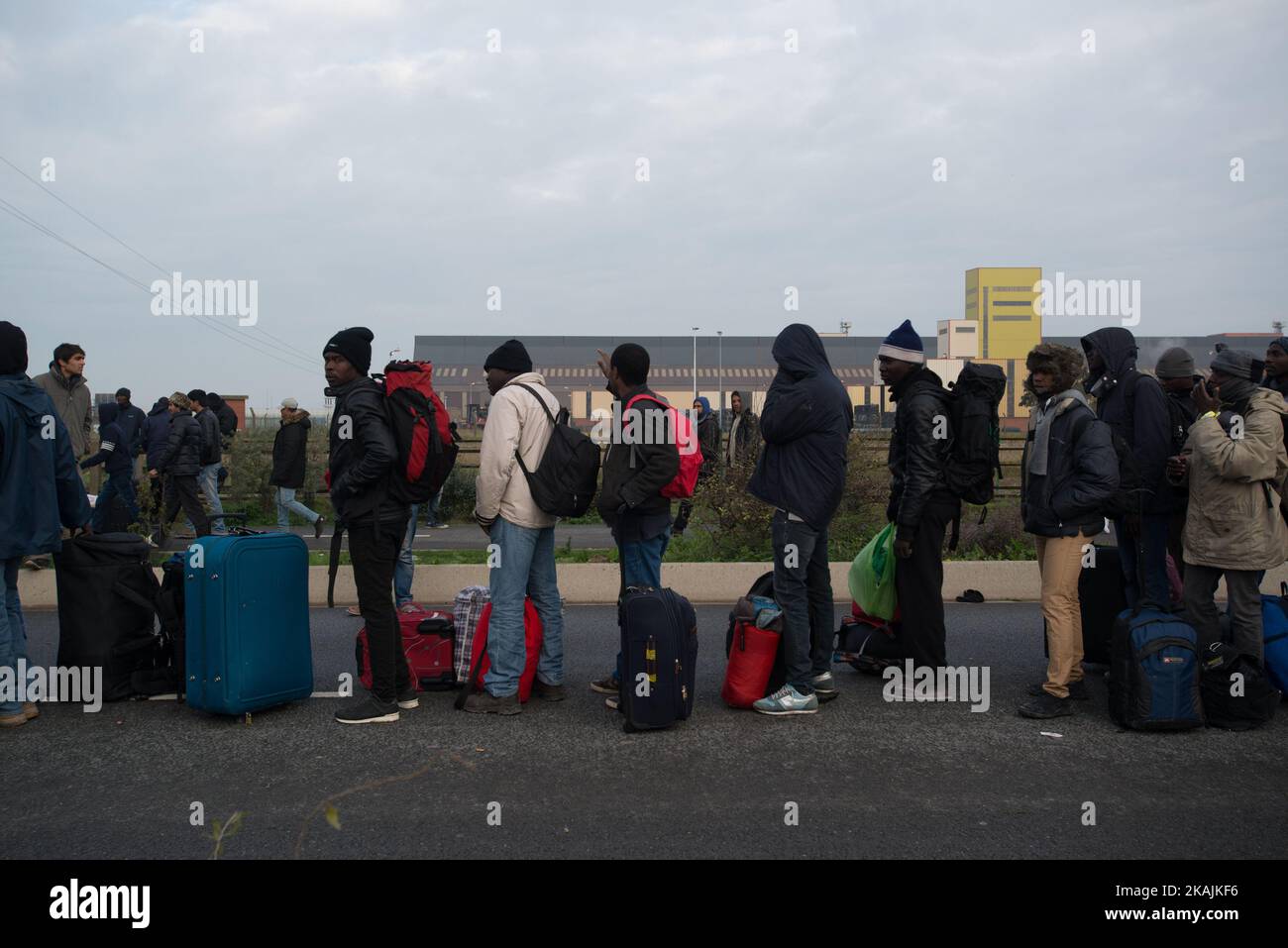 Les migrants faisant la queue pour prendre le bus à Calais, France, le 24 octobre 2016. Un tiers des migrants vivant dans la Jungle a été aujourd'hui enregistré et envoyé des vias diverses régions du territoire français. On leur a demandé de faire la queue devant un entrepôt où on leur a donné un bracelet d'une couleur spécifique. Ils sont finalement arrivés dans le bus qui leur a été attribué. (Photo de Guillaume Pinon/NurPhoto) *** Veuillez utiliser le crédit du champ de crédit *** Banque D'Images