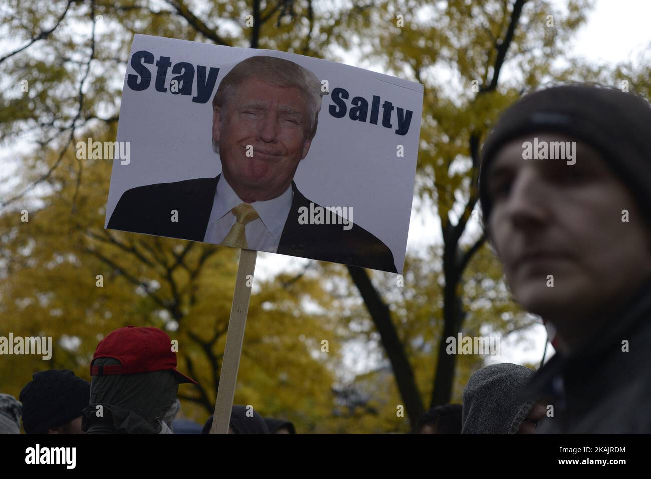 Un homme qui marche avec une affiche « salée » avec l'image de Donald Trump devant la Trump Tower à Toronto, au Canada, le 19 novembre 2016. Les manifestants se sont rassemblés devant la Trump Tower, dans le centre-ville de Toronto, pour exprimer leur chagrin et leur colère face aux récentes élections où Donal Trump a été élu futur président des États-Unis d'Amérique. (Photo par Arindam Shivaani/NurPhoto) *** Veuillez utiliser le crédit du champ de crédit *** Banque D'Images