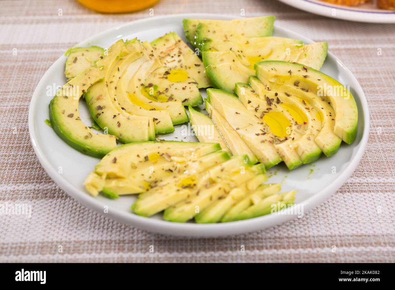 pulpe d'avocat mûre coupée en morceaux saupoudrée de jus de citron sur une assiette Banque D'Images