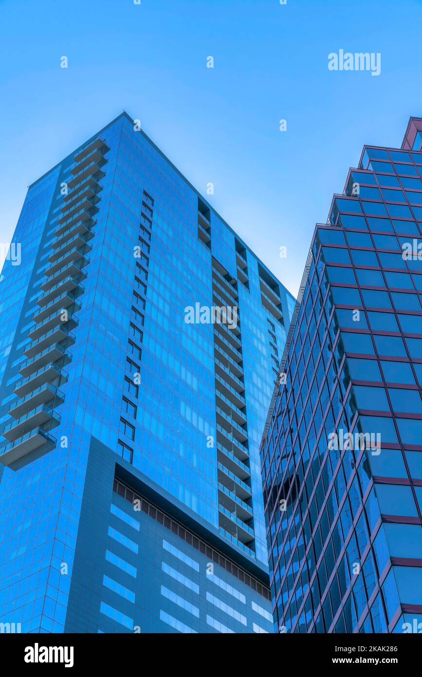 Gratte-ciel d'affaires avec façade vitrée reflétant le ciel bleu clair. Vue depuis l'extérieur d'un bâtiment commercial moderne dans le centre-ville d'Austin, Texas Banque D'Images