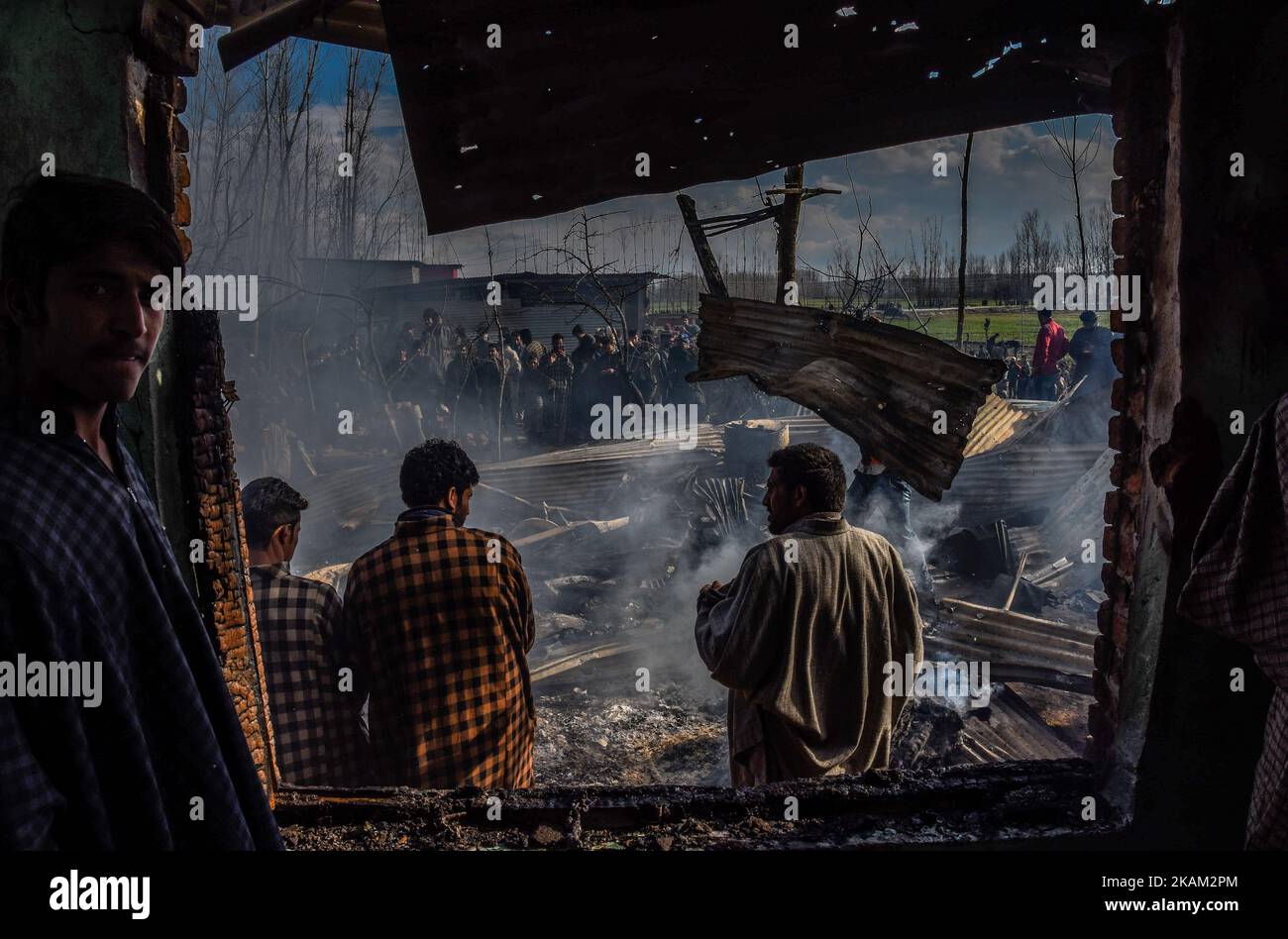 Les musulmans cachemiriens regardent vers les débris de la guerre ravagés maison résidentielle après une bataille à coups d'armes entre les forces gouvernementales indiennes et les rebelles cachemiriens sur 09 mars 2017 à Padgampauvres, à 30 kilomètres (18 miles) au sud de Srinagar, la capitale estivale du Cachemire administré par l'Inde, en Inde. Deux civils, dont un adolescent, ont été tués lors d'affrontements avec les forces gouvernementales indiennes lorsqu'ils ont essayé de sauver les rebelles locaux engagés dans une bataille d'armes à feu avec les forces les rebelles ont également été tués dans la bataille d'armes à feu plus tard dans la journée, Dans le district de Pulwom, au sud du Cachemire. (Photo de Yawar Nahir/Nur photo) *** P Banque D'Images