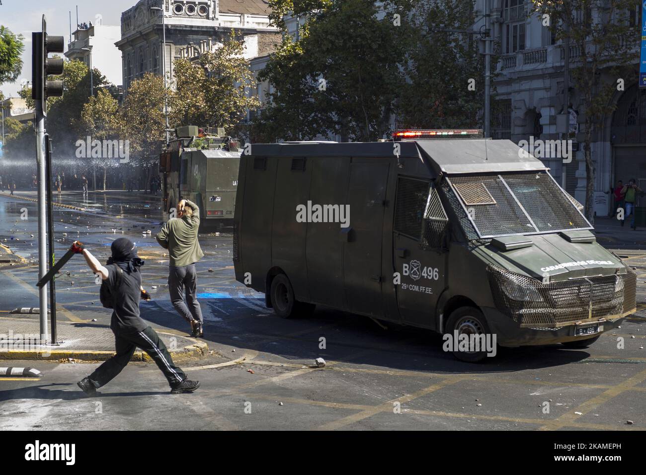 Un manifestant lance un objet sur une voiture de police. Des milliers d'étudiants ont marché à travers l'avenue principale de Santiago, sur 11 avril 2017, exigeant une libre, qualité, L'éducation publique démocratique et sans but lucratif, ainsi que le rejet du projet de réforme de l'éducation promu par le gouvernement de Michelle Bachelet. (Photo de Mauricio Gomez/NurPhoto) *** Veuillez utiliser le crédit du champ de crédit *** Banque D'Images