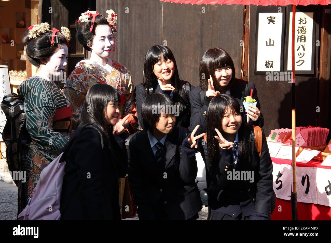 Des femmes asiatiques vêtues de geishas posant avec un groupe de lycéennes japonaises à Kyoto, au Japon Banque D'Images