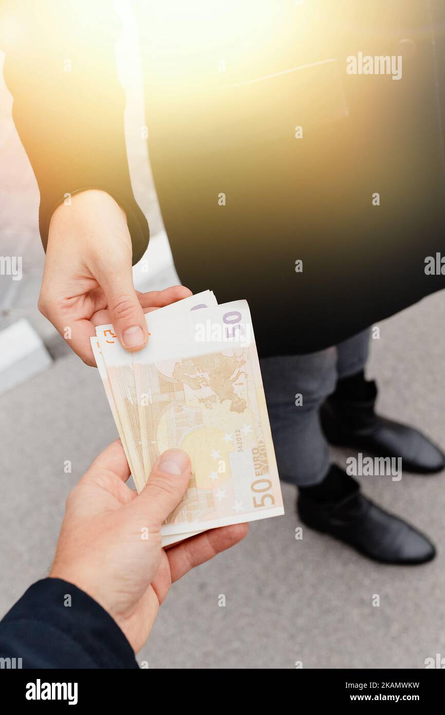 Homme donnant de l'argent à la femme. Espèces euros en main. Finances Banque D'Images