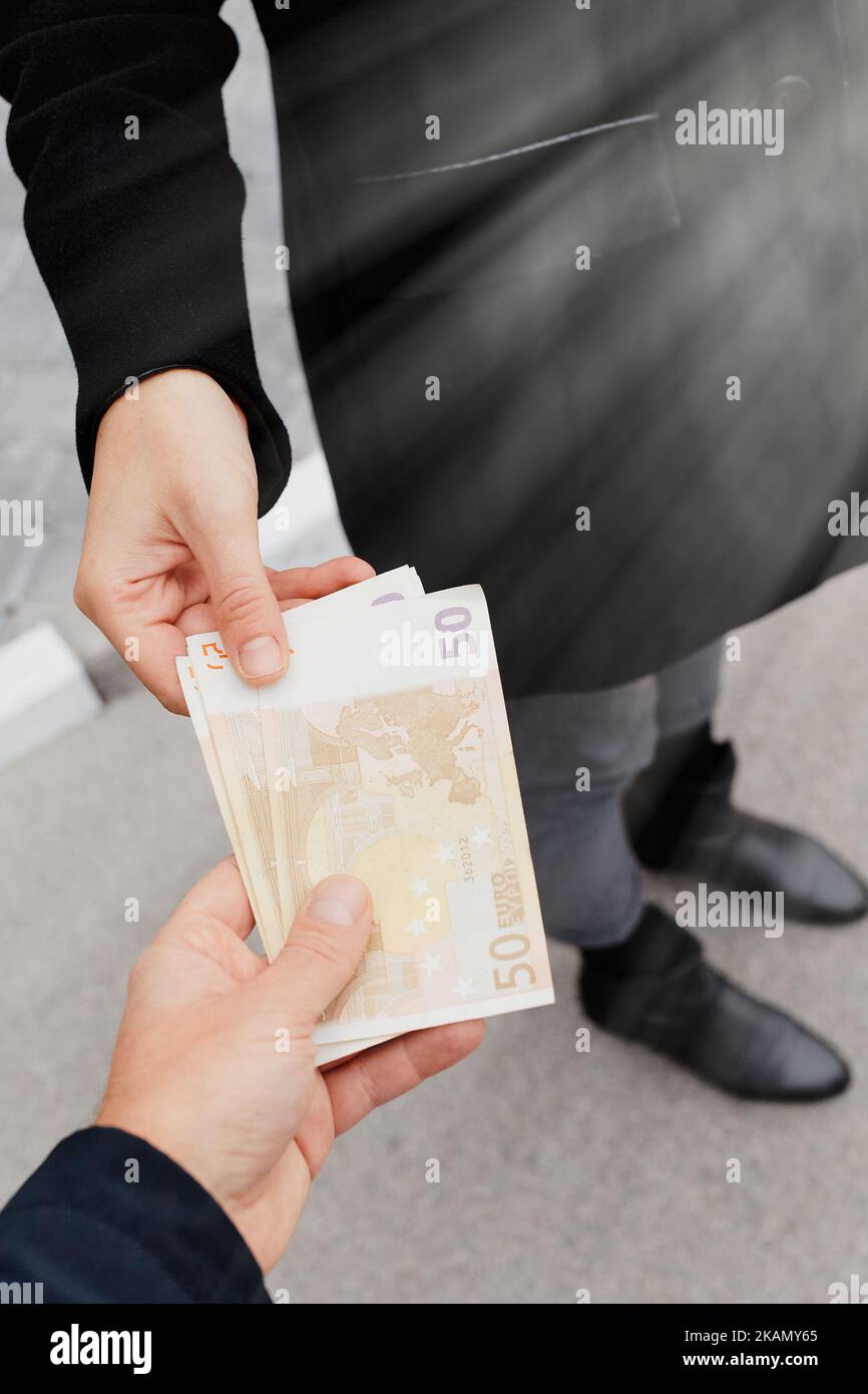 Homme donnant de l'argent à la femme. Espèces euros en main. Finances Banque D'Images