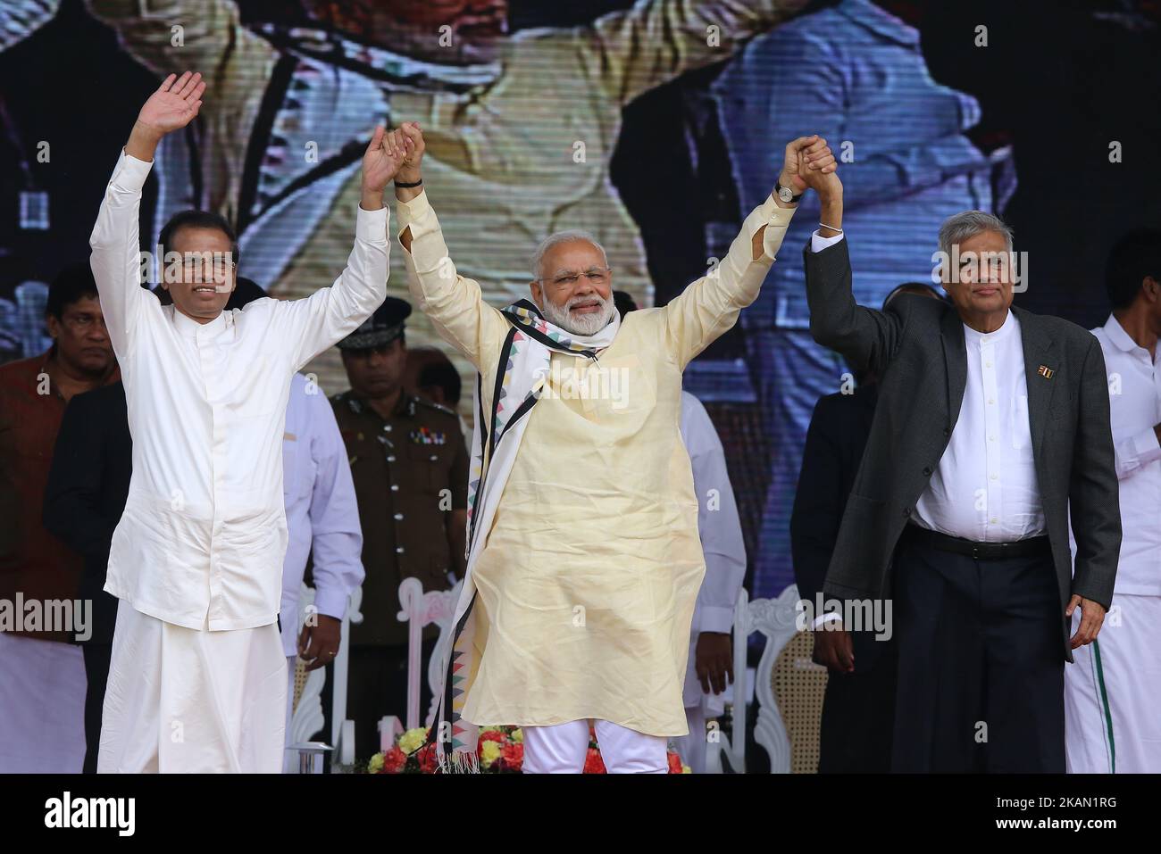 Maithripala Sirisena, présidente sri-lankaise, à gauche, Narendra Modi, premier ministre indien, centre, Et le Premier ministre sri-lankais Ranil Wickremesinghe se tient les mains et se délaye vers les travailleurs de plantations de thé sri-lankais d'origine indienne lors d'un rassemblement à Norwood, à environ 140 kilomètres (87,5 miles) à l'est de Colombo, Sri Lanka, vendredi, 12 mai 2017. Pendant sa visite de deux jours, Modi a participé à la célébration par les Nations Unies du Vesak ou du jour de naissance, d'illumination et de mort du Bouddha et a inauguré un hôpital moderne au profit des travailleurs de plantation de thé, ancêtres des ouvriers indiens amenés par le Brit Banque D'Images