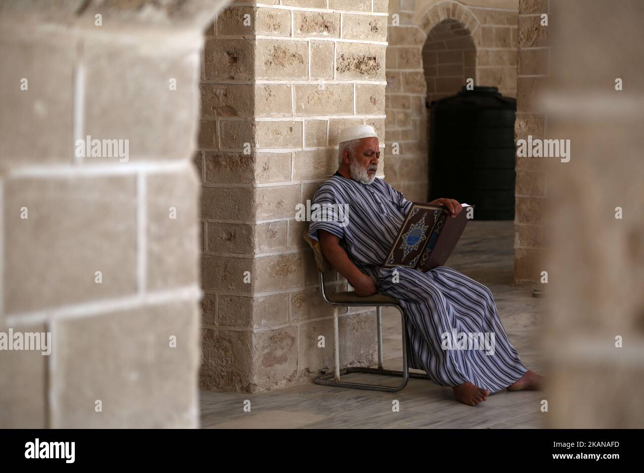 Un palestinien lit une copie du Coran, le livre le plus sacré de l'Islam, le premier jour de jeûne dans le mois sacré musulman du Ramadan, à la mosquée al-Omari de Gaza, sur 27 mai 2017. Plus de 1,5 milliards de musulmans dans le monde marqueront le mois, au cours duquel les croyants s'abstiendront de manger, de boire et de fumer de l'aube au coucher du soleil. (Photo de Majdi Fathi/NurPhoto) *** Veuillez utiliser le crédit du champ de crédit *** Banque D'Images