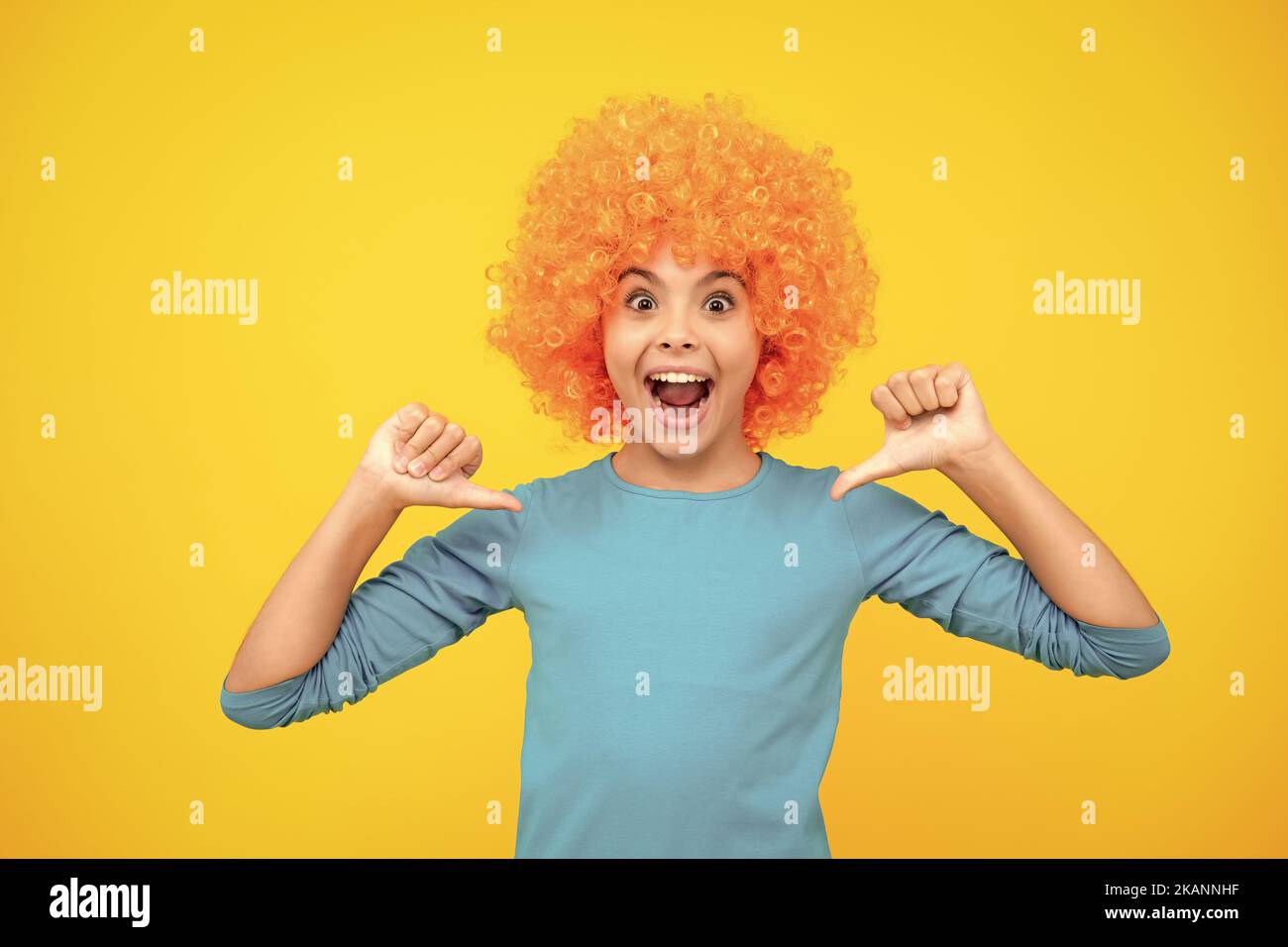 Belle adolescente dans perruque isolée sur jaune. Perruque clown amusante. Adolescent excité, heureux surpris et surjoyeux émotions. Banque D'Images