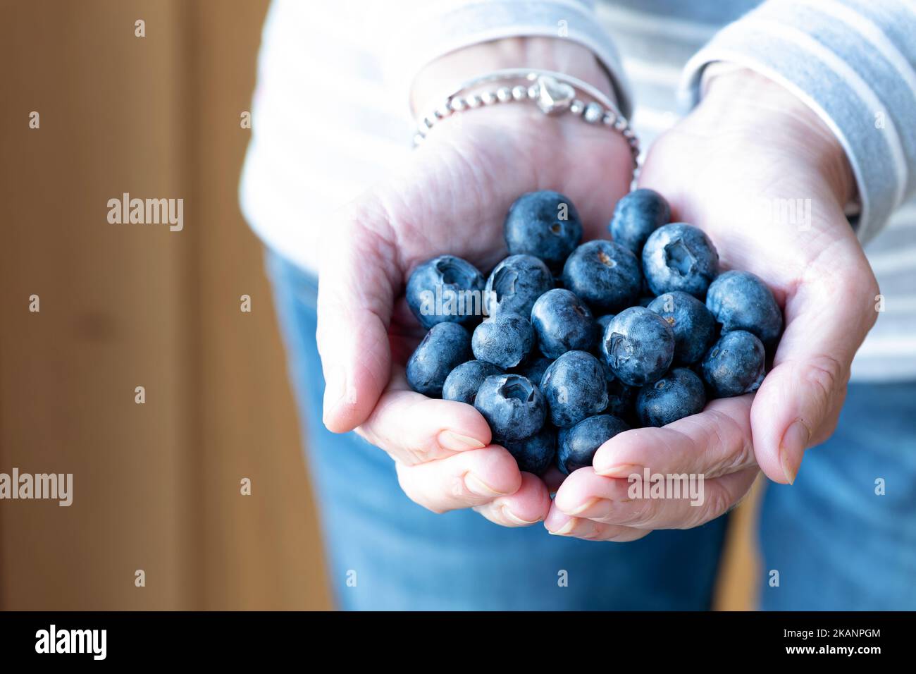 Une femme portant une portion quotidienne recommandée de bleuets. La mesure de la portion est de 150g ou une tasse. Les antioxydants sains sont riches en vitamines Banque D'Images Une femme portant une portion quotidienne recommandée de bleuets. La mesure de la portion est de 150g ou une tasse. Les antioxydants sains sont riches en vitamines Banque D'Images