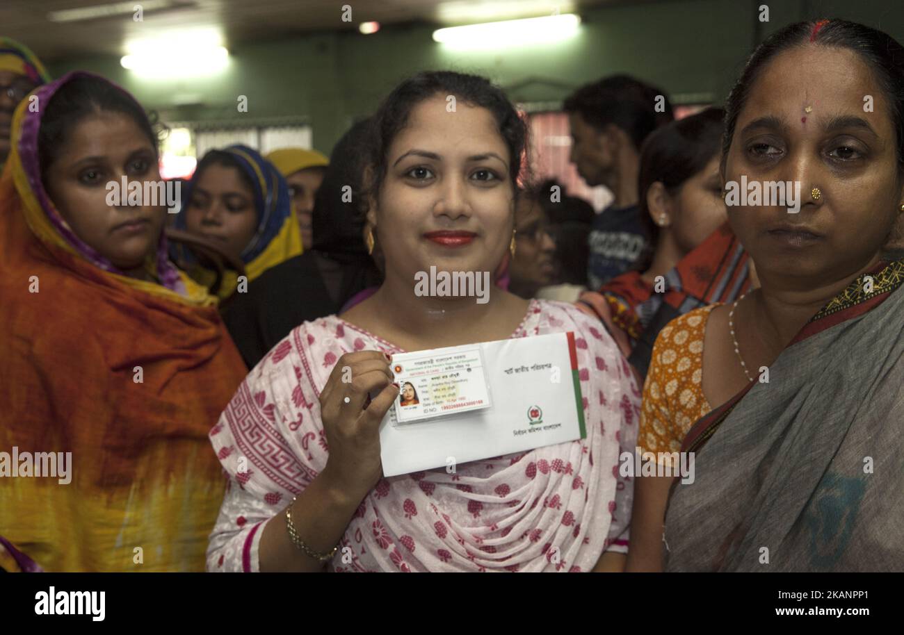 Le 15 juin 2017, un personnel de la commission électorale scanne l'iris et l'empreinte digitale d'un électeur dans un camp temporaire établi dans la vieille partie de Dhaka Lalkuthi près du bureau du conseiller dans la capitale. Selon la Commission électorale du Bangladesh, il y a actuellement plus de 10 000 électeurs grossis au Bangladesh. Parmi eux, neuf crore auront des cartes NID intelligentes cette année dans le cadre d'un projet en cours. Les fonctionnaires de la ce collecteraient les détails biométriques du citoyen, les impressions de 10 doigts et une photo de l'iris, qui serait intégrée à la puce de la carte. La carte lisible par machine contient 32 types d'informations de base Banque D'Images