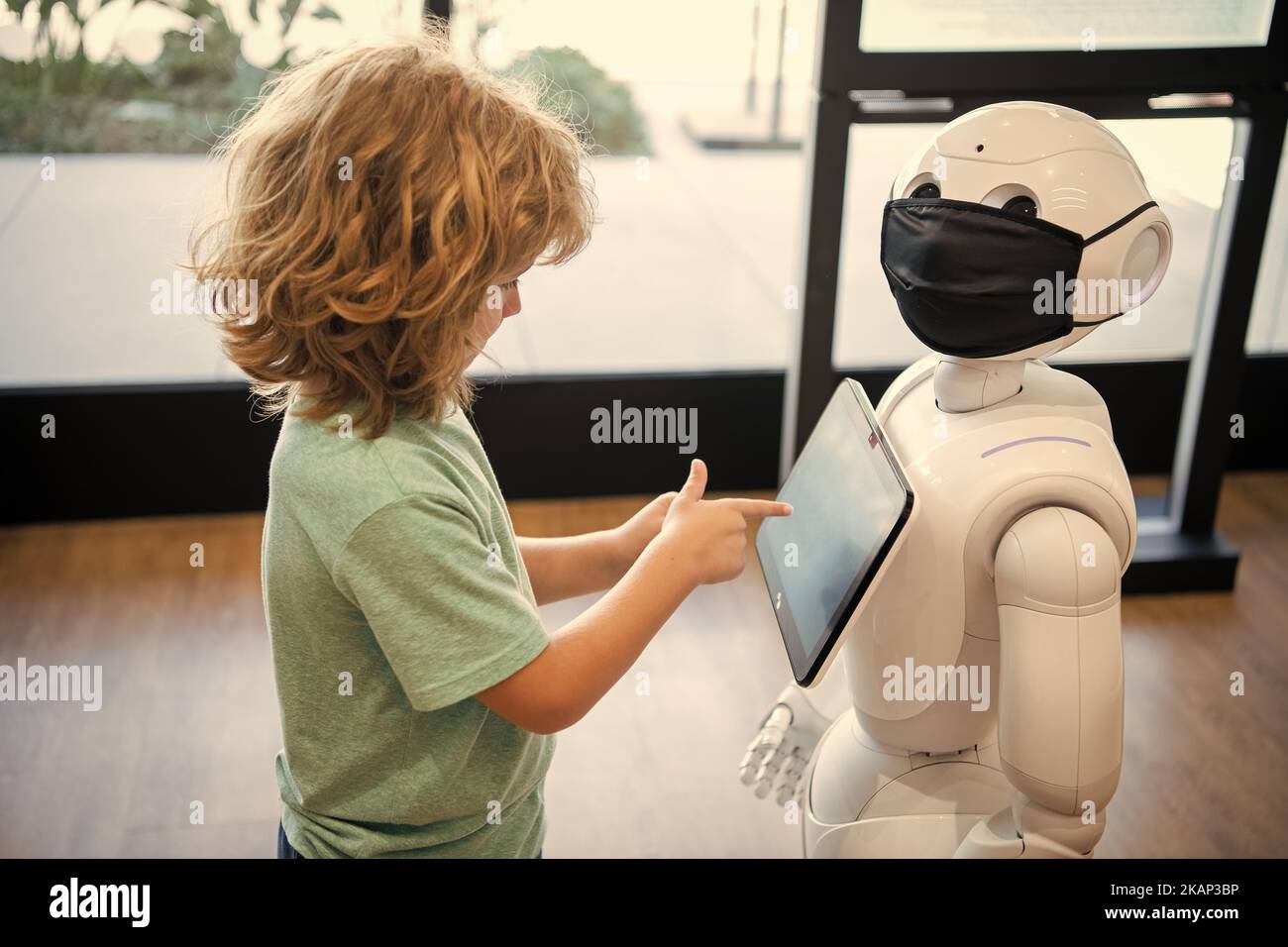 un gamin occupé interagit avec l'intelligence artificielle du robot, la communication Banque D'Images