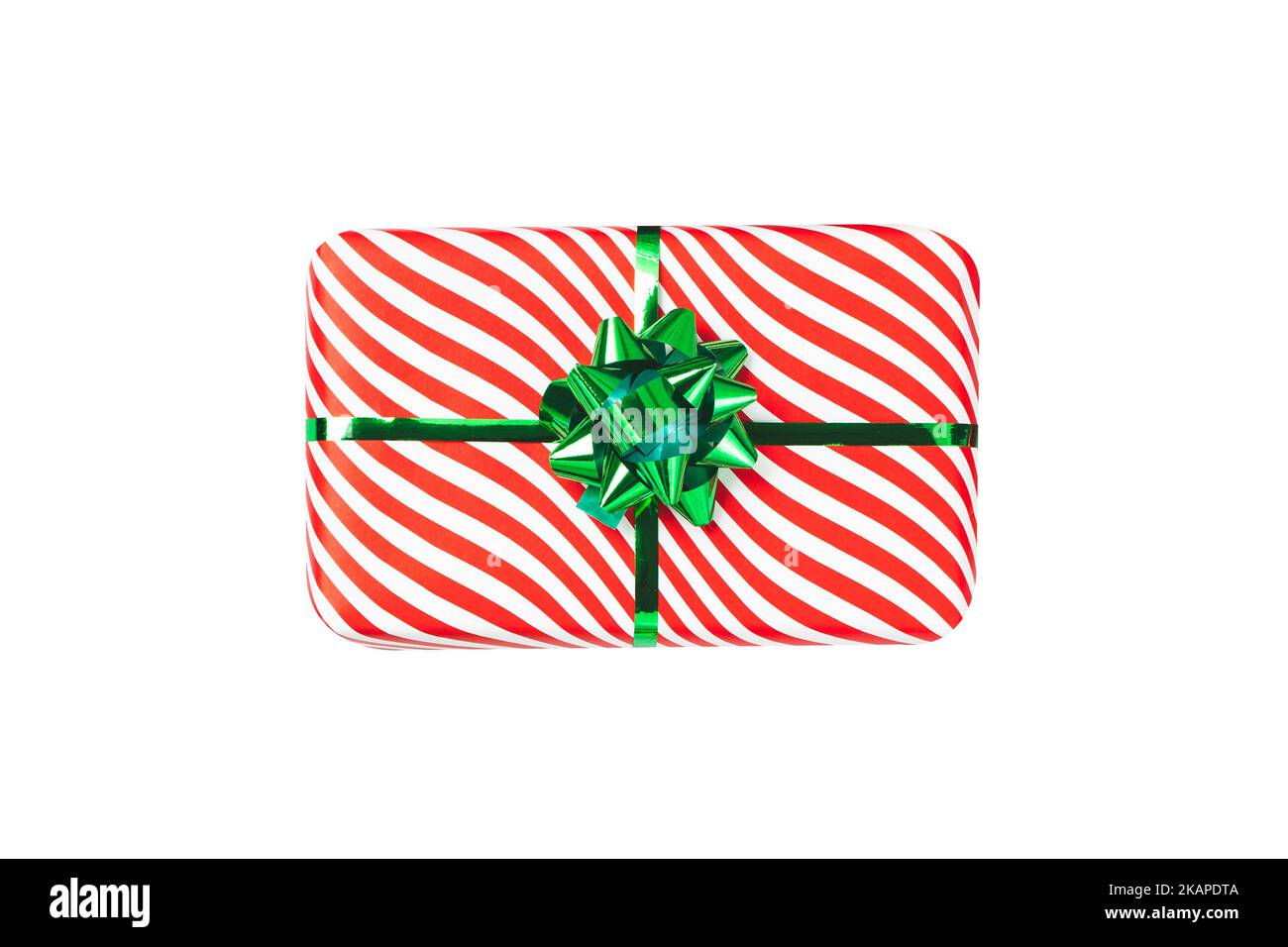 Boîte cadeau rouge emballée avec boucle en ruban vert brillant, objet isolé sur fond blanc. Un emballage rayé de vacances, vue du dessus. Cadeau de Noël, nouvel an Banque D'Images