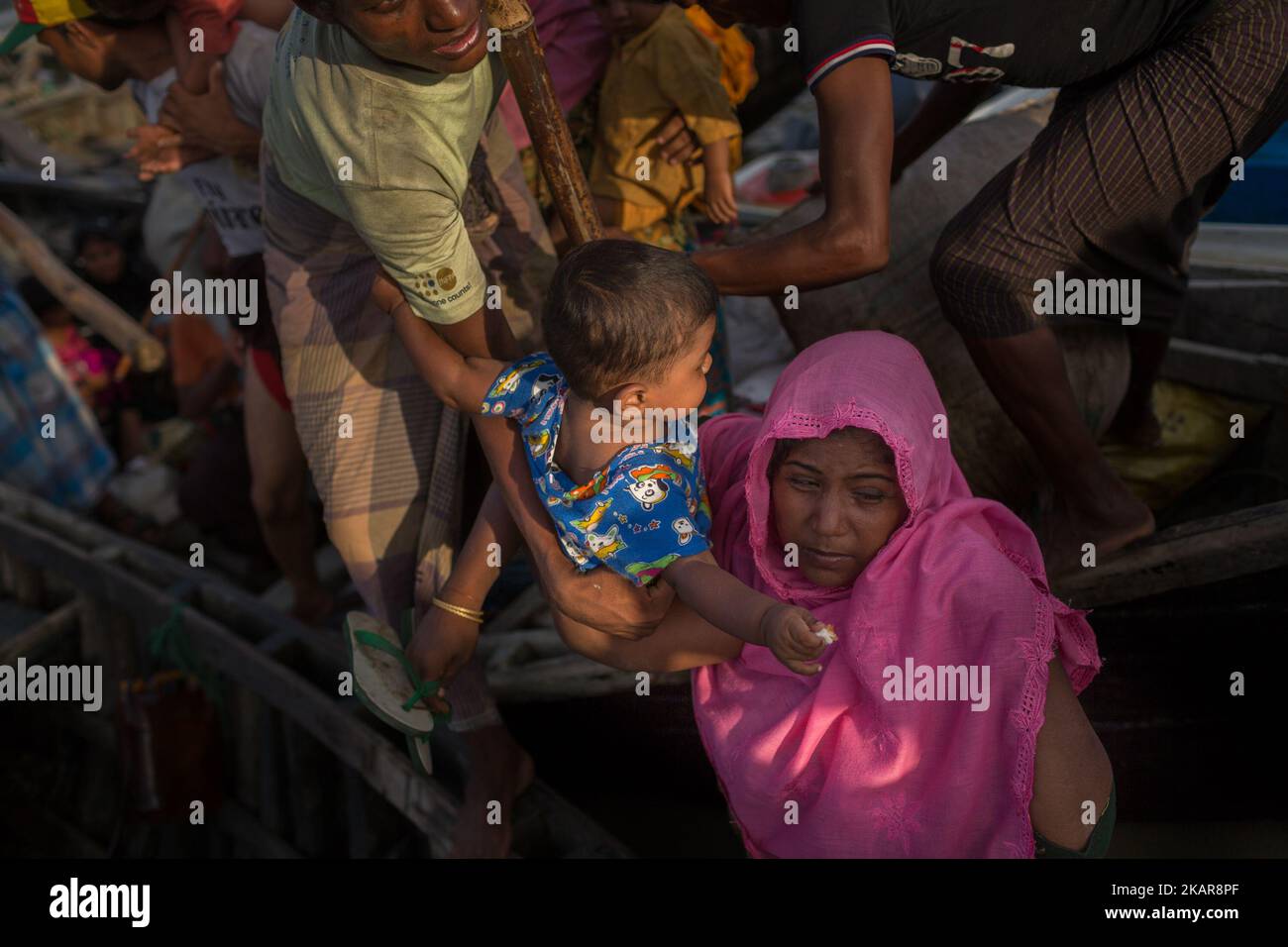 Une mère de Rohingya tient son enfant après être sortie du bateau. Shahpirer DIP, Teknaf, Bangladesh ; 14 septembre 2017. Le Bangladesh utilisera des troupes pour fournir une aide étrangère à la ville frontalière submergée par les réfugiés musulmans Rohingya du Myanmar, ont annoncé à la fin du 14 septembre. Cette décision fait suite à la critique des conditions chaotiques dans lesquelles les secours ont été distribués dans les immenses camps autour de Cox's Bazar, où environ 389 000 Rohingya de l'État Rakhine du Myanmar sont arrivés depuis 25 août. (Photo de Turjoy Chowdhury/NurPhoto) Banque D'Images