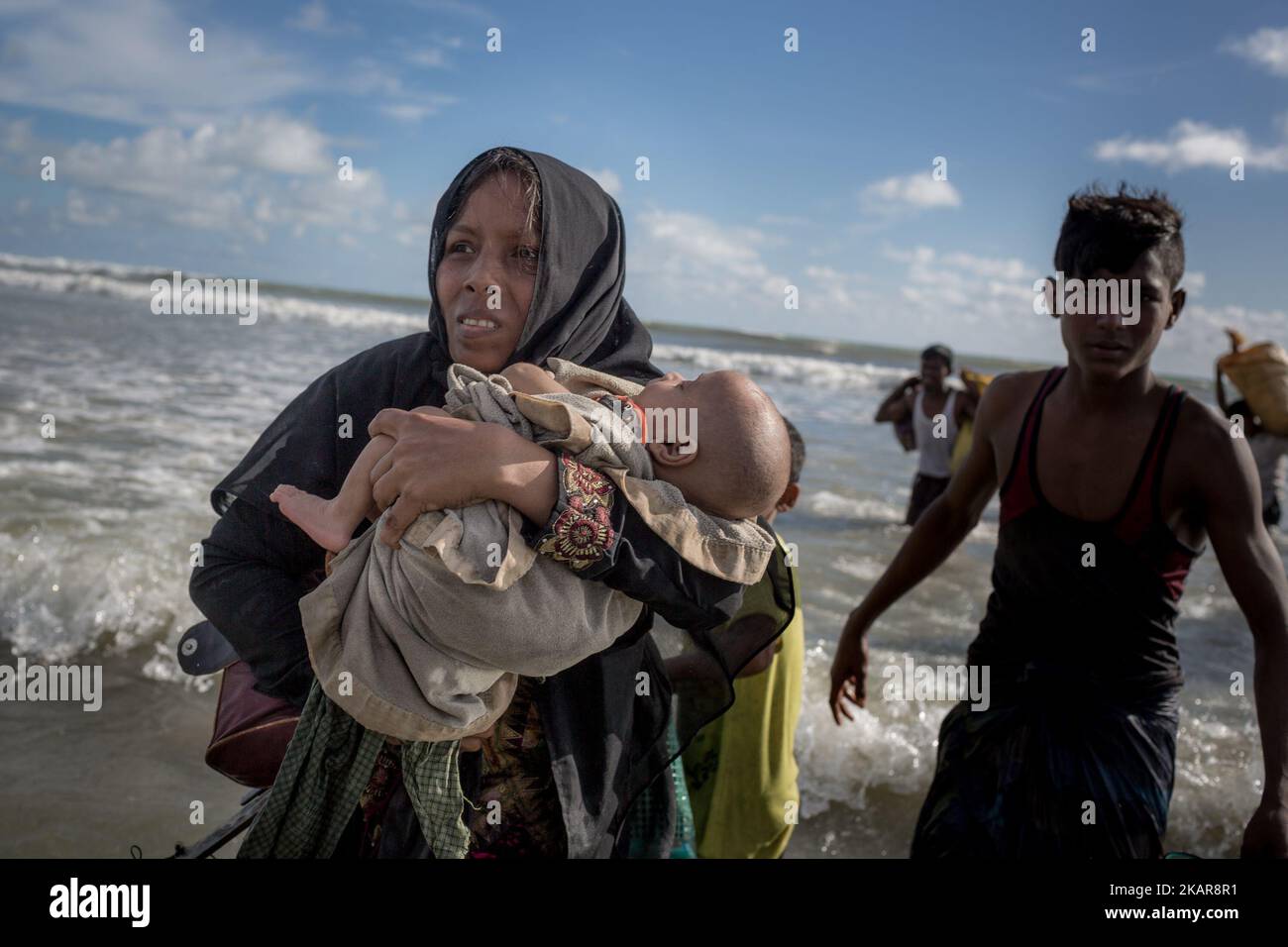 Une mère de Rohingya avec son enfant de deux mois se rend sur la rive après avoir traversé la NAF par bateau. Shahpirer DIP, Teknaf, Bangladesh ; 14 septembre 2017. Le Bangladesh utilisera des troupes pour fournir une aide étrangère à la ville frontalière submergée par les réfugiés musulmans Rohingya du Myanmar, ont annoncé à la fin du 14 septembre. Cette décision fait suite à la critique des conditions chaotiques dans lesquelles les secours ont été distribués dans les immenses camps autour de Cox's Bazar, où environ 389 000 Rohingya de l'État Rakhine du Myanmar sont arrivés depuis 25 août. (Photo de Turjoy Chowdhury/NurPhoto) Banque D'Images
