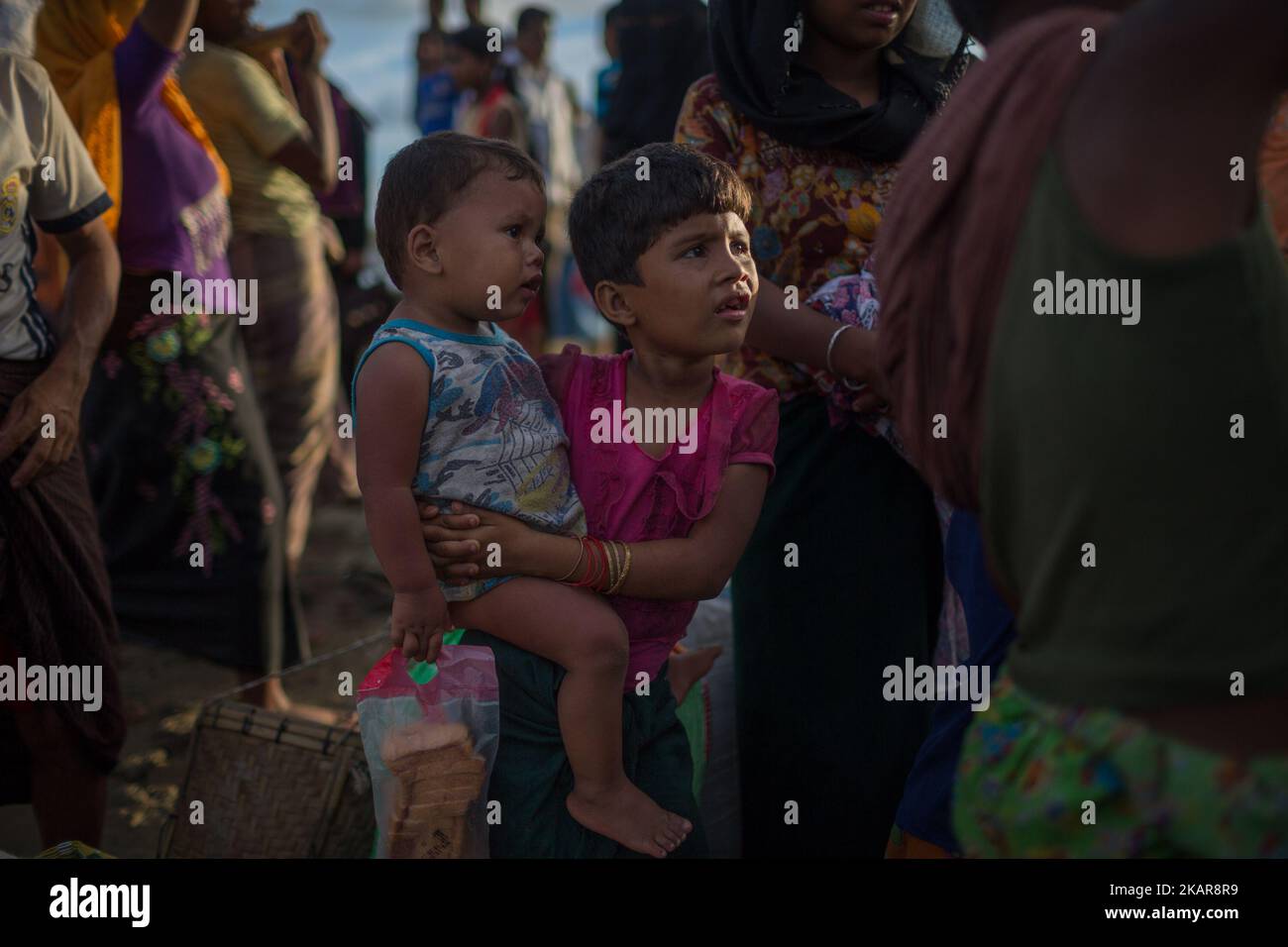 Un enfant de Rohingya attend à la banque avec son frère cadet. Shahpirer DIP, Teknaf, Bangladesh ; 14 septembre 2017. Le Bangladesh utilisera des troupes pour fournir une aide étrangère à la ville frontalière submergée par les réfugiés musulmans Rohingya du Myanmar, ont annoncé à la fin du 14 septembre. Cette décision fait suite à la critique des conditions chaotiques dans lesquelles les secours ont été distribués dans les immenses camps autour de Cox's Bazar, où environ 389 000 Rohingya de l'État Rakhine du Myanmar sont arrivés depuis 25 août. (Photo de Turjoy Chowdhury/NurPhoto) Banque D'Images