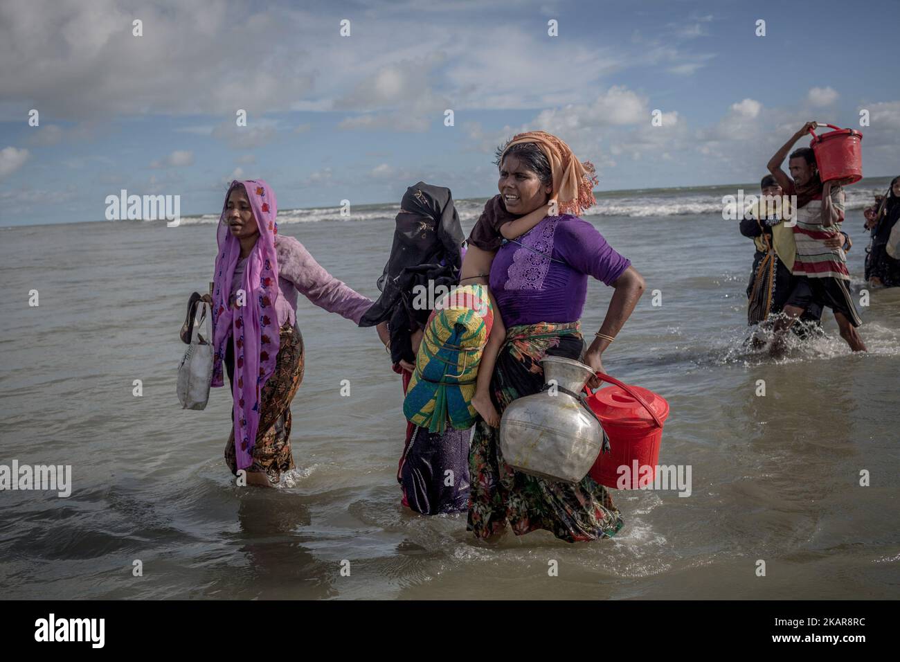 Les réfugiées Rohingya marchent jusqu'à la rive du Bangladesh après avoir traversé la NAF par bateau. Shahpirer DIP, Teknaf, Bangladesh ; 14 septembre 2017. Le Bangladesh utilisera des troupes pour fournir une aide étrangère à la ville frontalière submergée par les réfugiés musulmans Rohingya du Myanmar, ont annoncé à la fin du 14 septembre. Cette décision fait suite à la critique des conditions chaotiques dans lesquelles les secours ont été distribués dans les immenses camps autour de Cox's Bazar, où environ 389 000 Rohingya de l'État Rakhine du Myanmar sont arrivés depuis 25 août. (Photo de Turjoy Chowdhury/NurPhoto) Banque D'Images