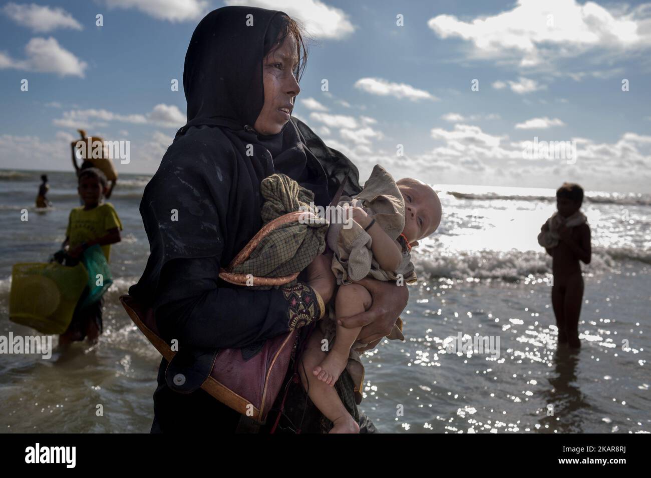 Une mère de Rohingya pleure, tenant son enfant de deux mois et se promène sur la rive après avoir traversé la rivière NAF en bateau. Shahpirer DIP, Teknaf, Bangladesh ; 14 septembre 2017. Le Bangladesh utilisera des troupes pour fournir une aide étrangère à la ville frontalière submergée par les réfugiés musulmans Rohingya du Myanmar, ont annoncé à la fin du 14 septembre. Cette décision fait suite à la critique des conditions chaotiques dans lesquelles les secours ont été distribués dans les immenses camps autour de Cox's Bazar, où environ 389 000 Rohingya de l'État Rakhine du Myanmar sont arrivés depuis 25 août. (Photo de Turjoy Chowdh Banque D'Images