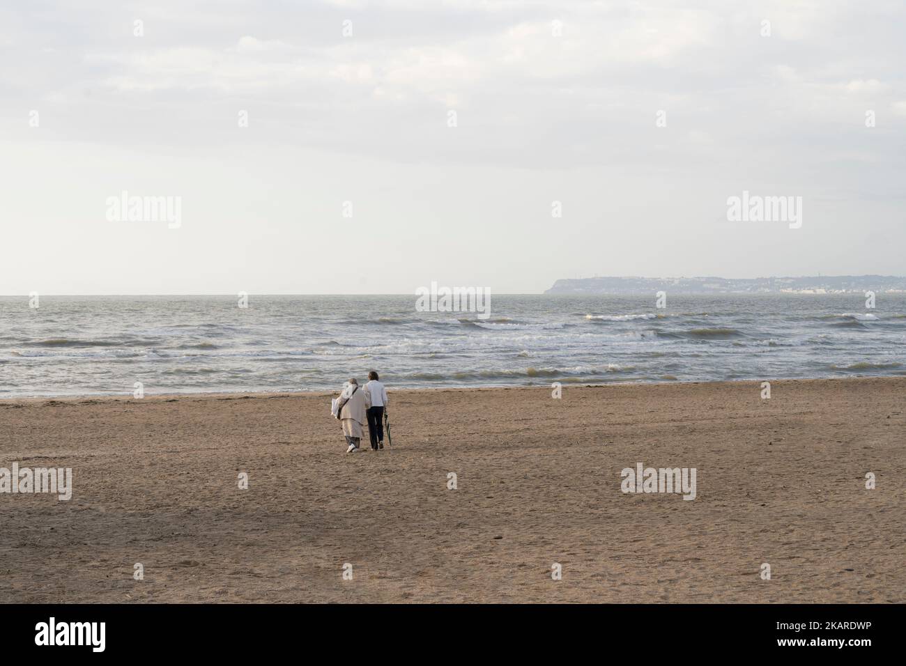 La vieille et la jeune femme isolée marche sur la plage de Trouville sur Mer Banque D'Images