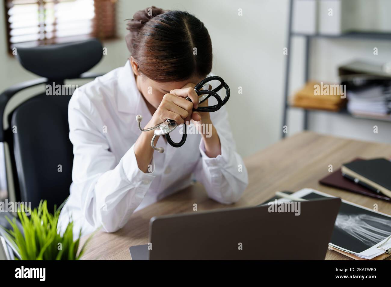 Une femme asiatique médecin utilise un ordinateur tout en montrant des inquiétudes au sujet des informations sur le patient Banque D'Images